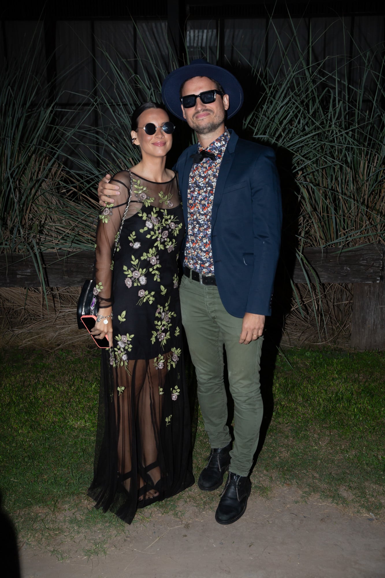 Vicky Ayerza (con vestido con transparencias estratégicas y estampa botánica) y Ángelo Conorti.