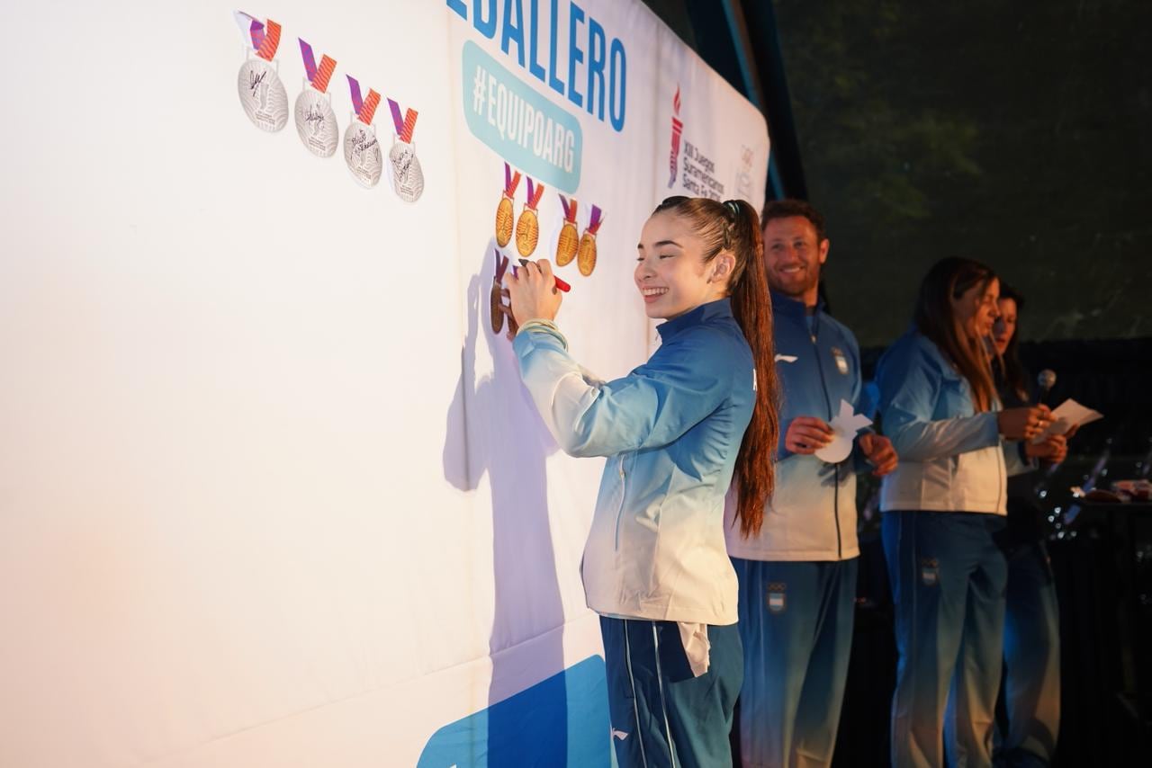 Los atletas pegaron sus medallas simbólicas en un panel y las autografiaron