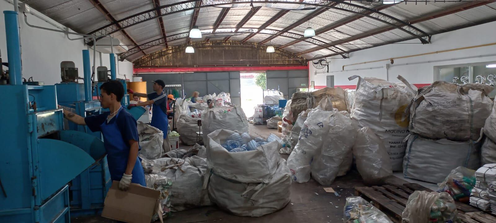 Dos operarios de la planta de separación de residuos del taller protegido Necochea en pleno trabajo de recuperación de basura