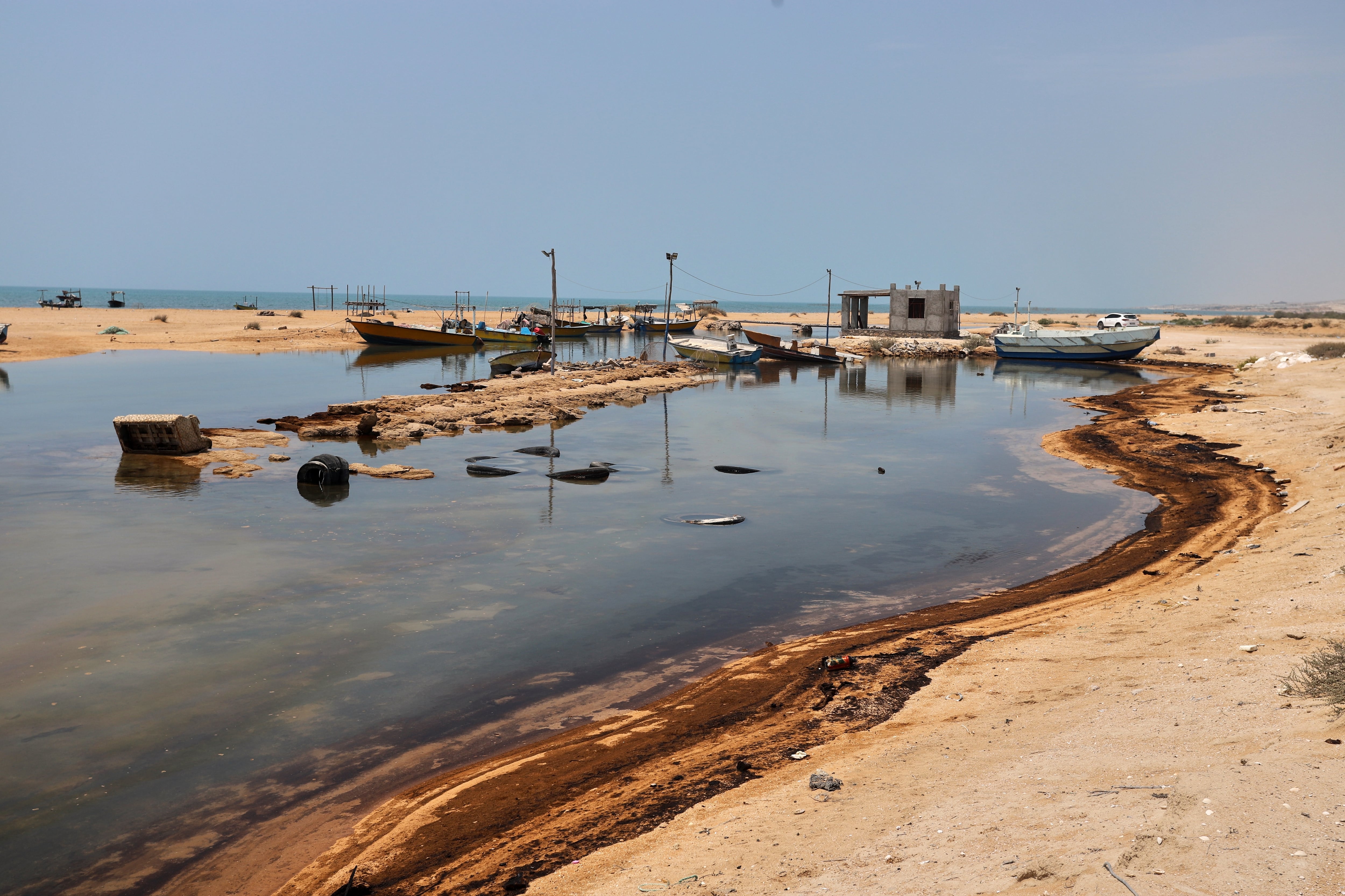 Residuos de petróleo cerca de botes pesqueros en la isla de Qeshm, Irán, el 13 de agosto de 2026, en medio de los continuos ataques de guerra contra embarcaciones e infraestructuras en y alrededor del estrecho de Ormuz. (Amirhosein Khorgooi/ISNA vía AP)