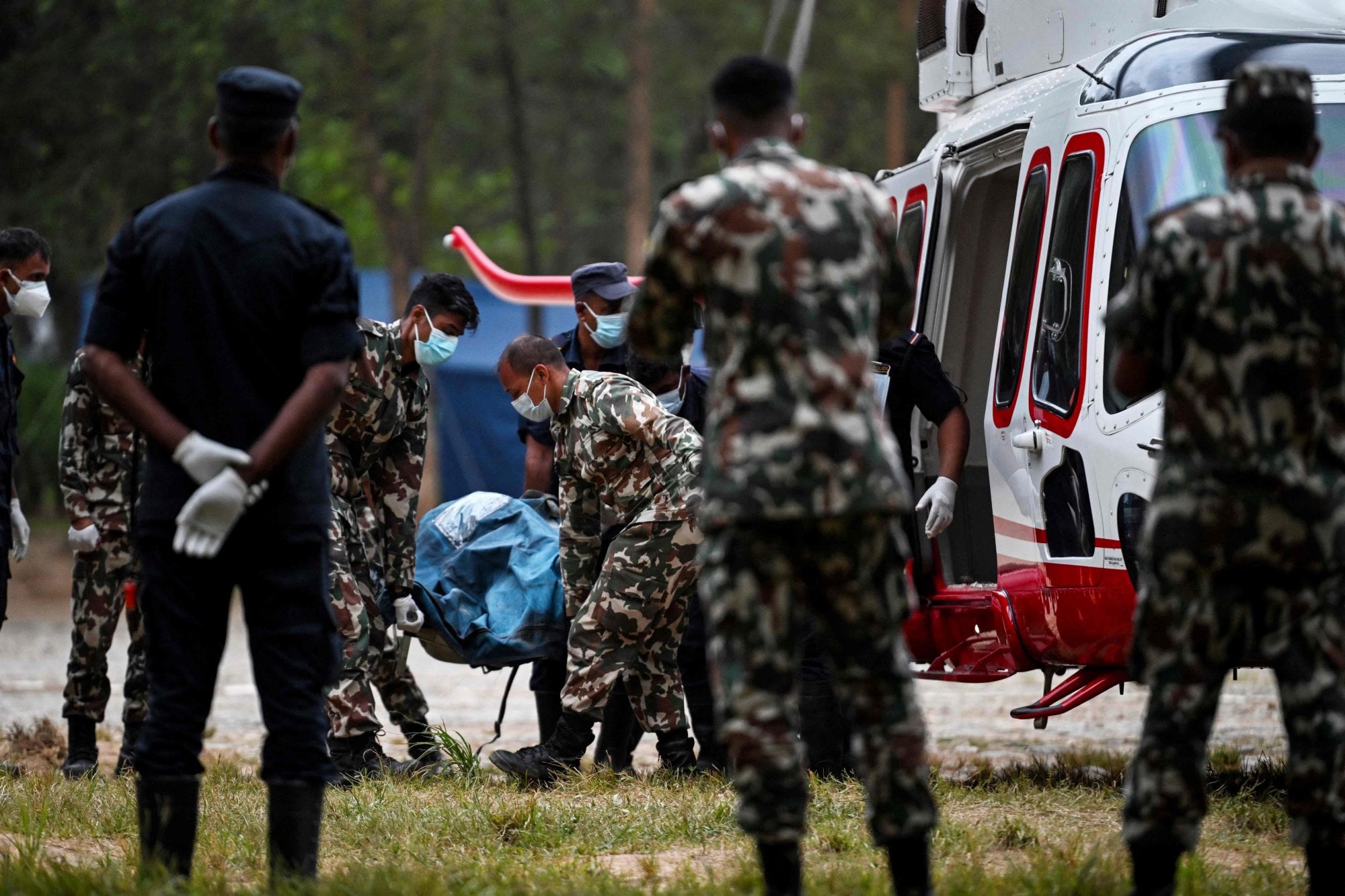 Personal del ejército traslada los cuerpos de víctimas desde un helicóptero en el campamento de Trishuli, en el distrito nepalí de Nuwakot, el 31 de agosto de 2026 (Arun Sankar/ AFP)