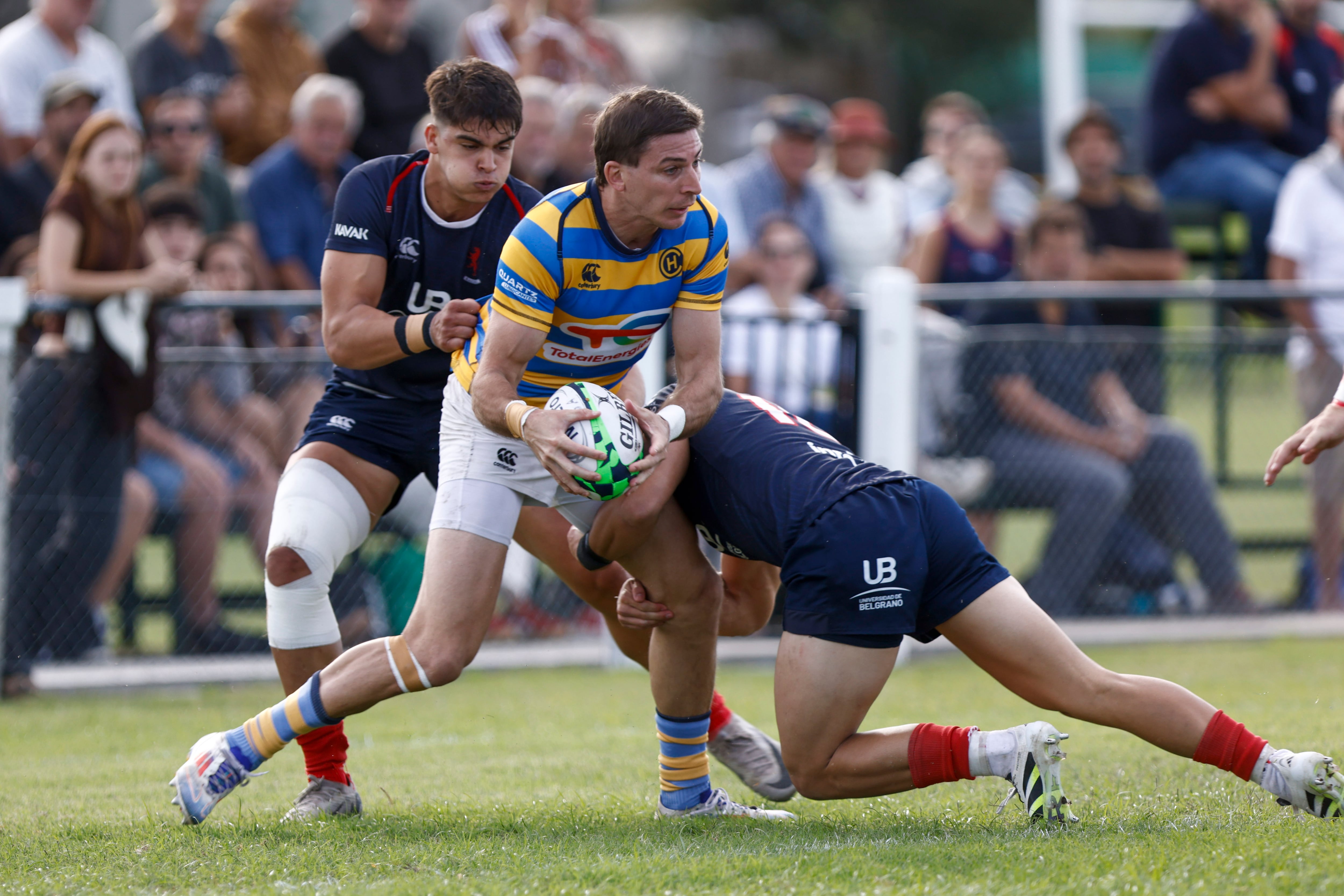 Sebastián Cancelliere tackleado por Agustín Lamensa; mira Ignacio Bensadón