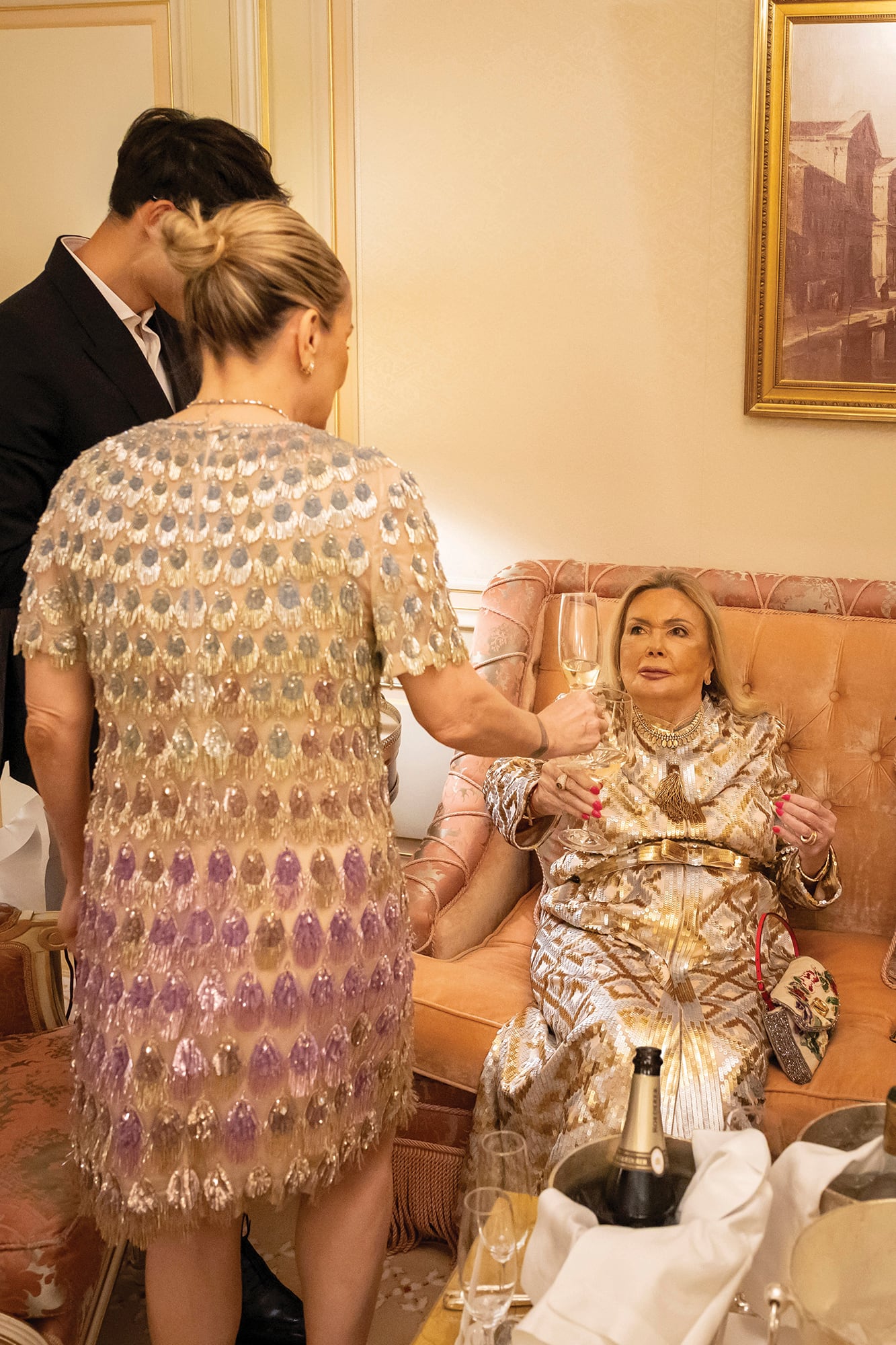 Mariana le acerca a su madre una copa de champagne para brindar