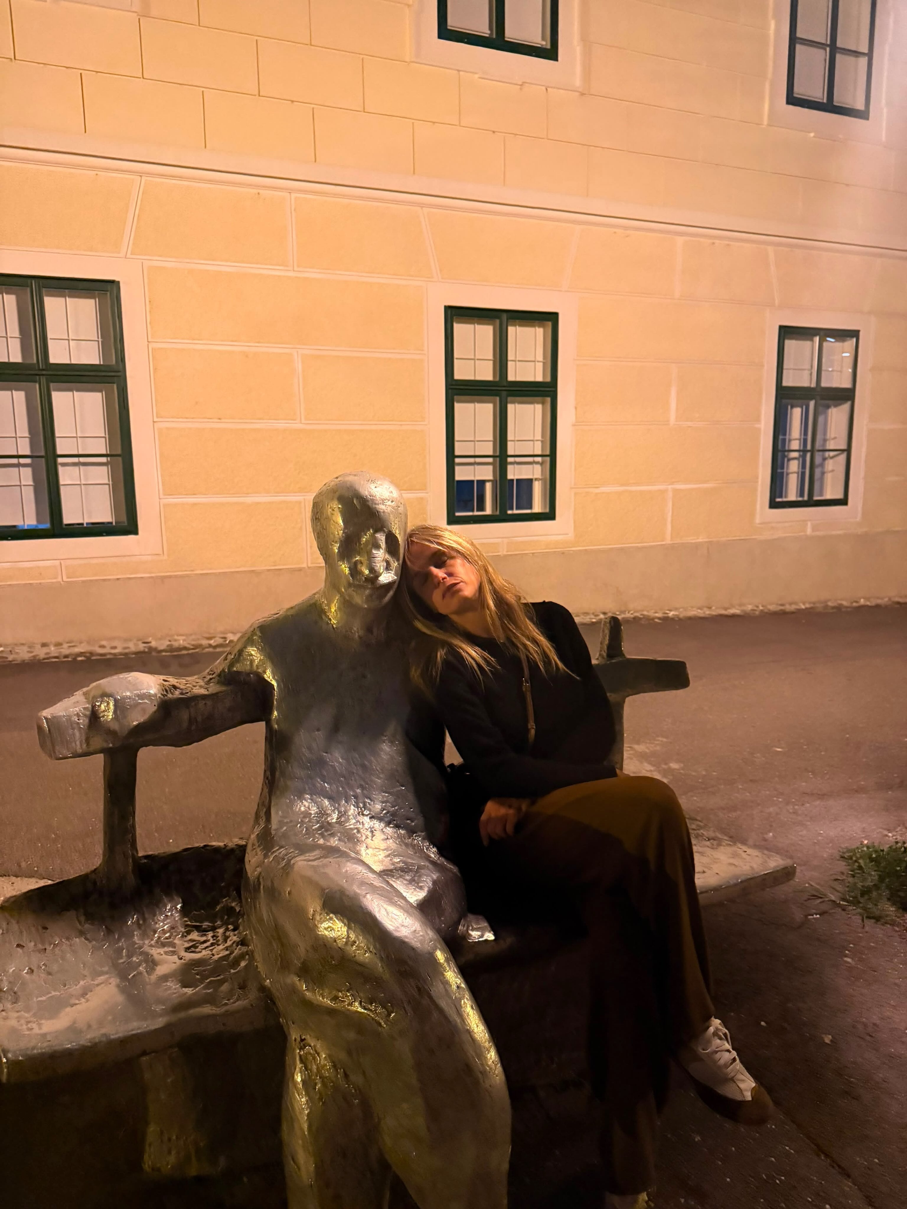 Fabbiani sentada en un banco junto a una escultura de bronce