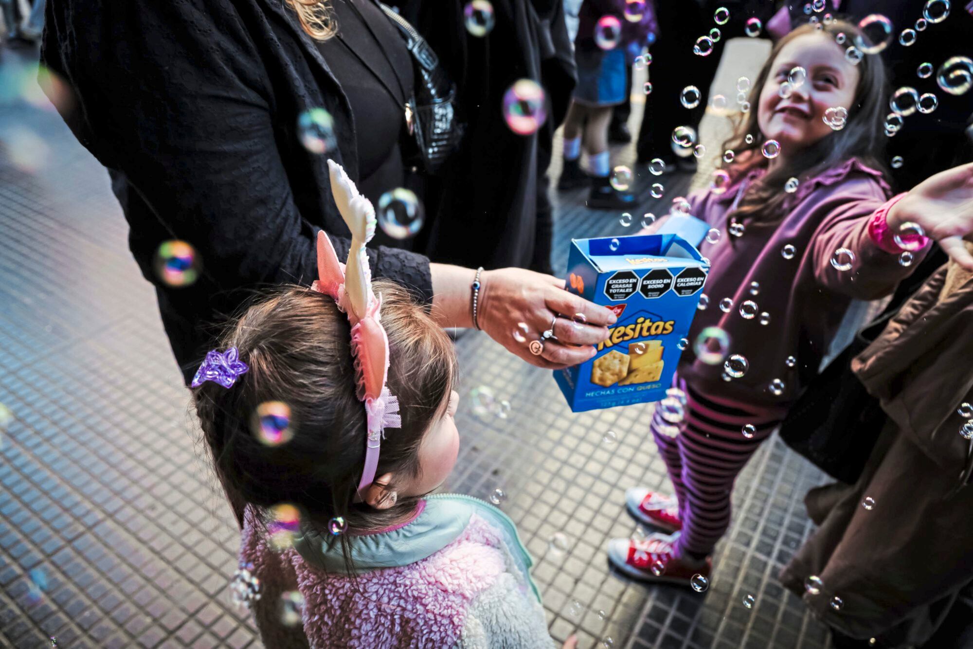 Las burbujas que se desparraman en las puertas de los teatros le dan a la calle Corrientes el colorido de un pop latino furioso