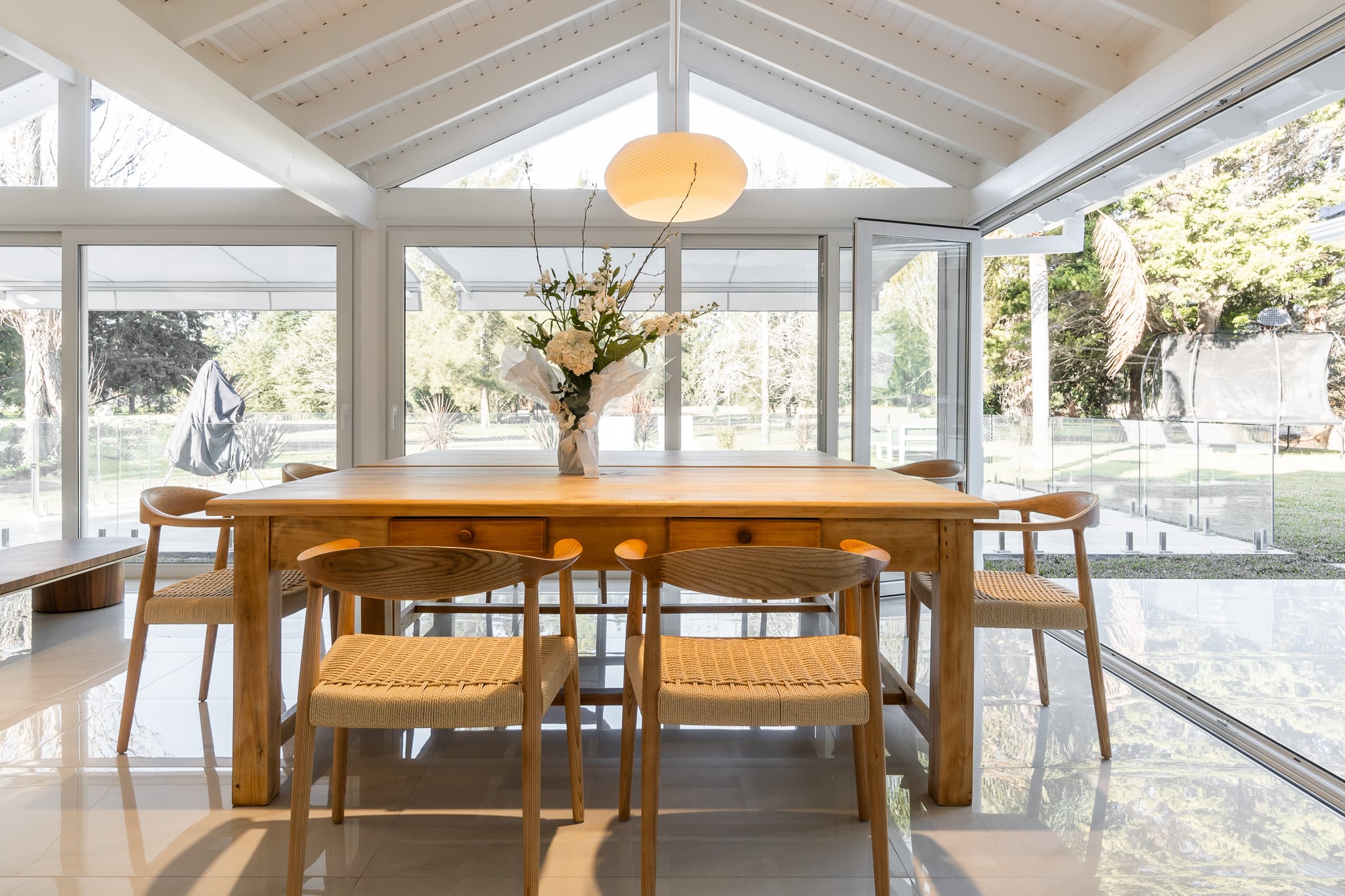 El uso de carpinterías tipo 'abanico' en PVC permiten abrir por completo el quincho y generar un espacio más amplio conectado al entorno natural