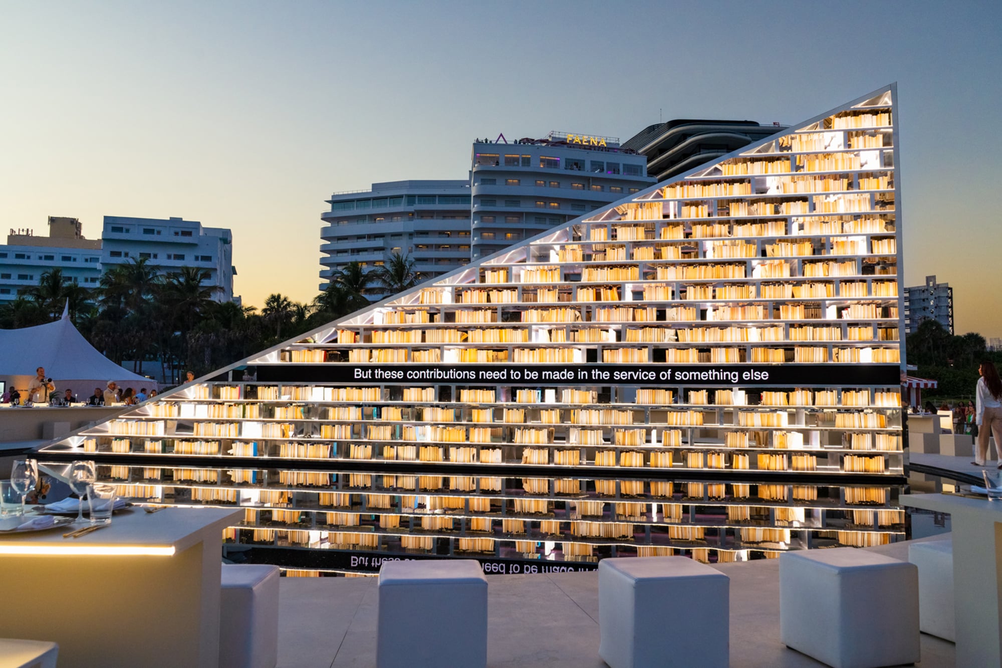 Esta inmensa biblioteca triangular de casi seis metros de altura y 15 de longitud, está rodeada por un espejo de agua y una mesa de lectura circular que, en conjunto, se expanden a más de 27 metros de diámetro