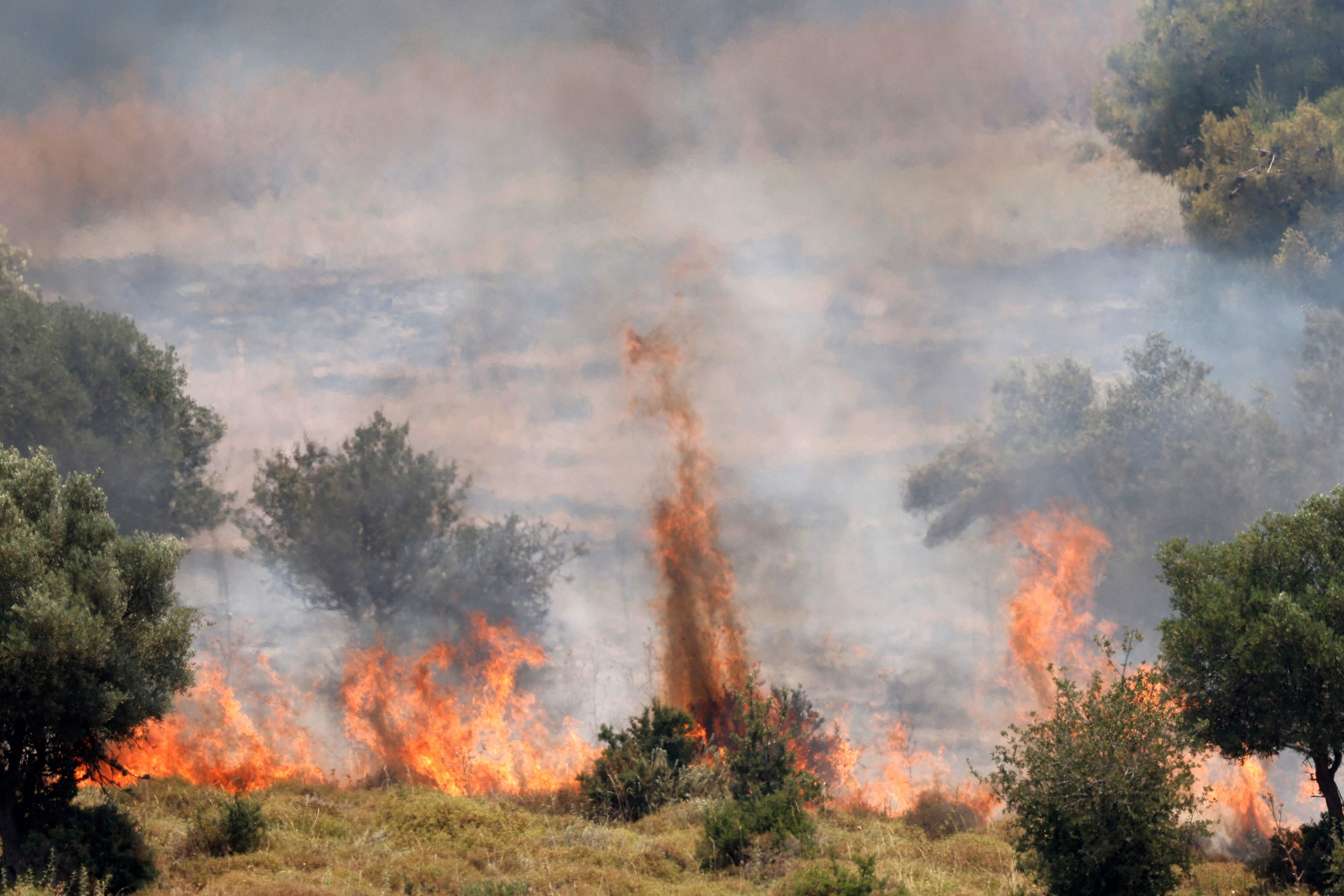 Incendios queman la vegetación después de que cohetes lanzados desde el sur del Líbano cayeran en las afueras de Safed, en la alta Galilea israelí, el 12 de junio de 2024. 
