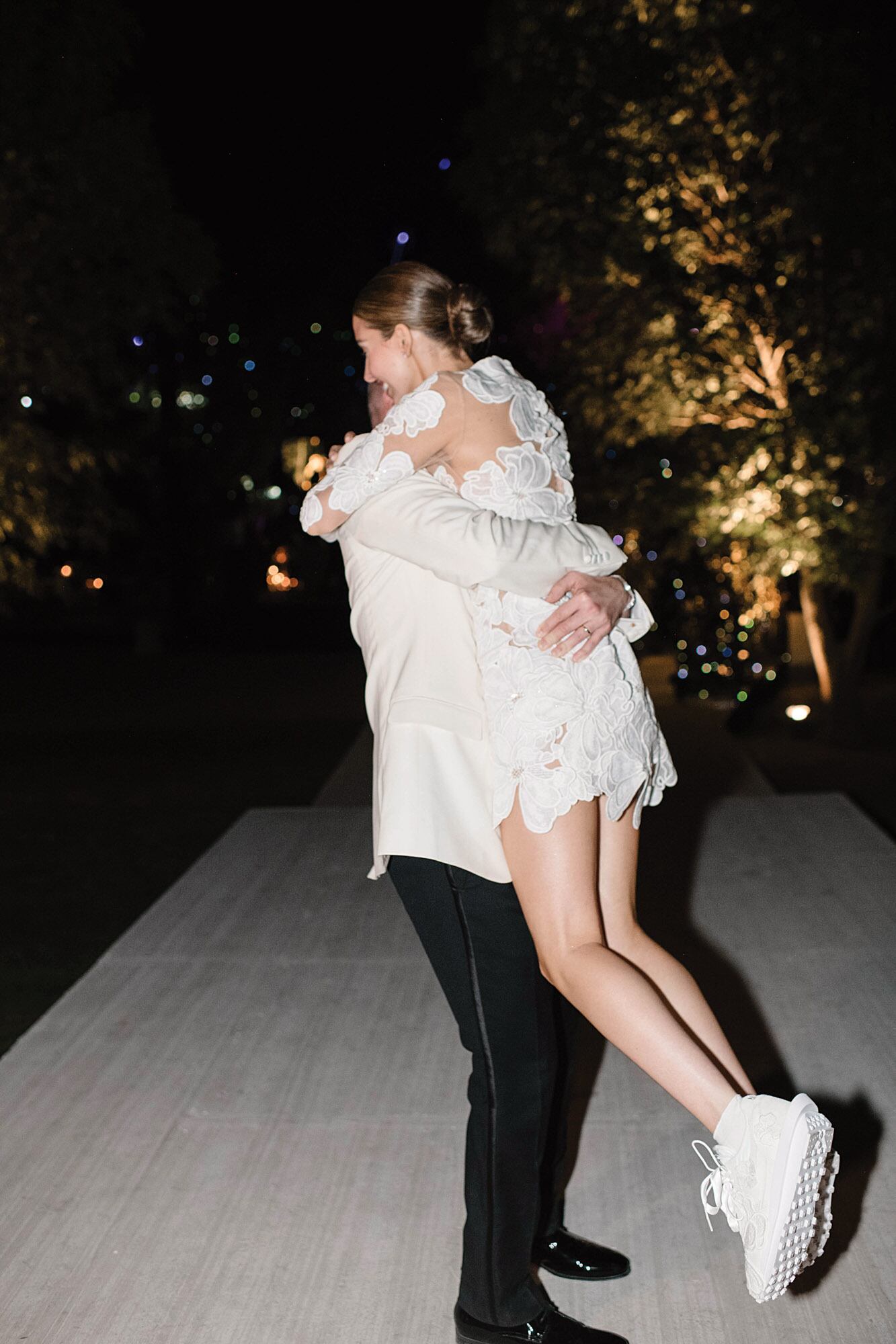 El abrazo de los novios en la fiesta. Ella lleva zapatillas y el vestido mini que su suegra le diseñó para que bailara más cómoda. 