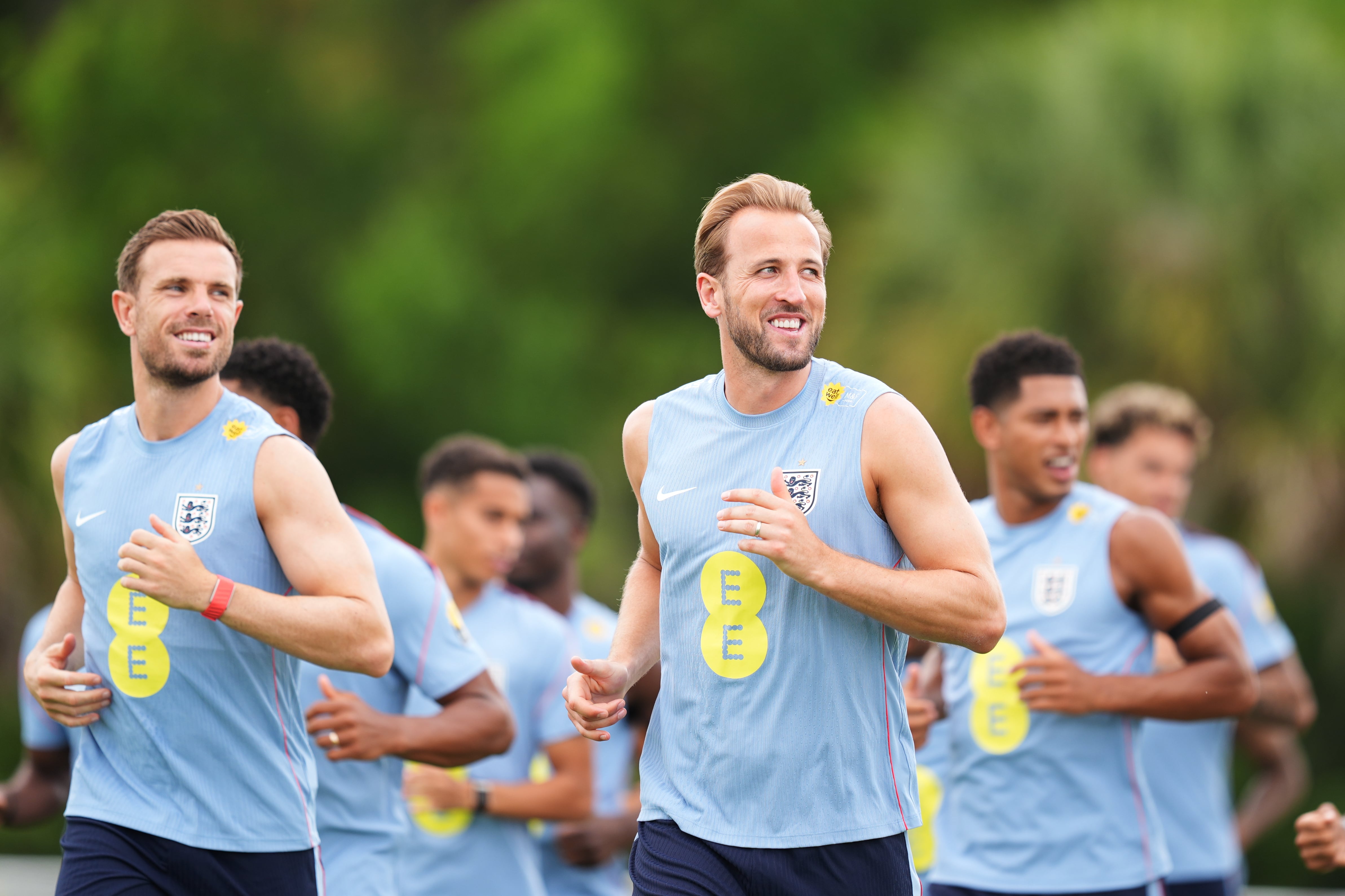 Los británicos Harry Kane, al centro, y Jordan Henderson, a la izquierda, trotan junto a sus compañeros durante la práctica de la selección de Inglaterra