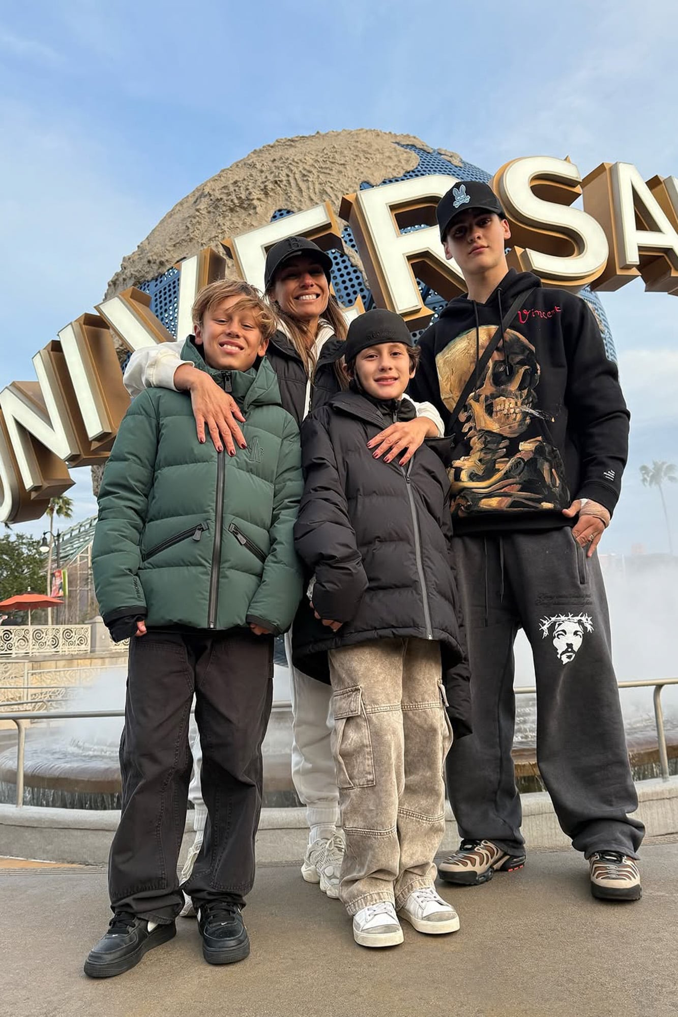 Carolina y sus tres hijos varones frente al cartel de Universal.