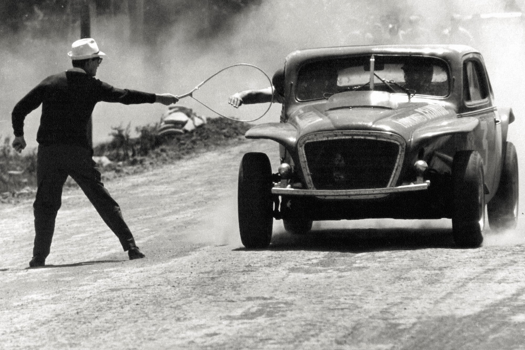 Las 1000 Millas Argentinas. Alberto Lozano recibe el “aro de información” de Norberto Mateos. Al no existir la radio, con este dispositivo se les informaba a los pilotos cómo iba la carrera