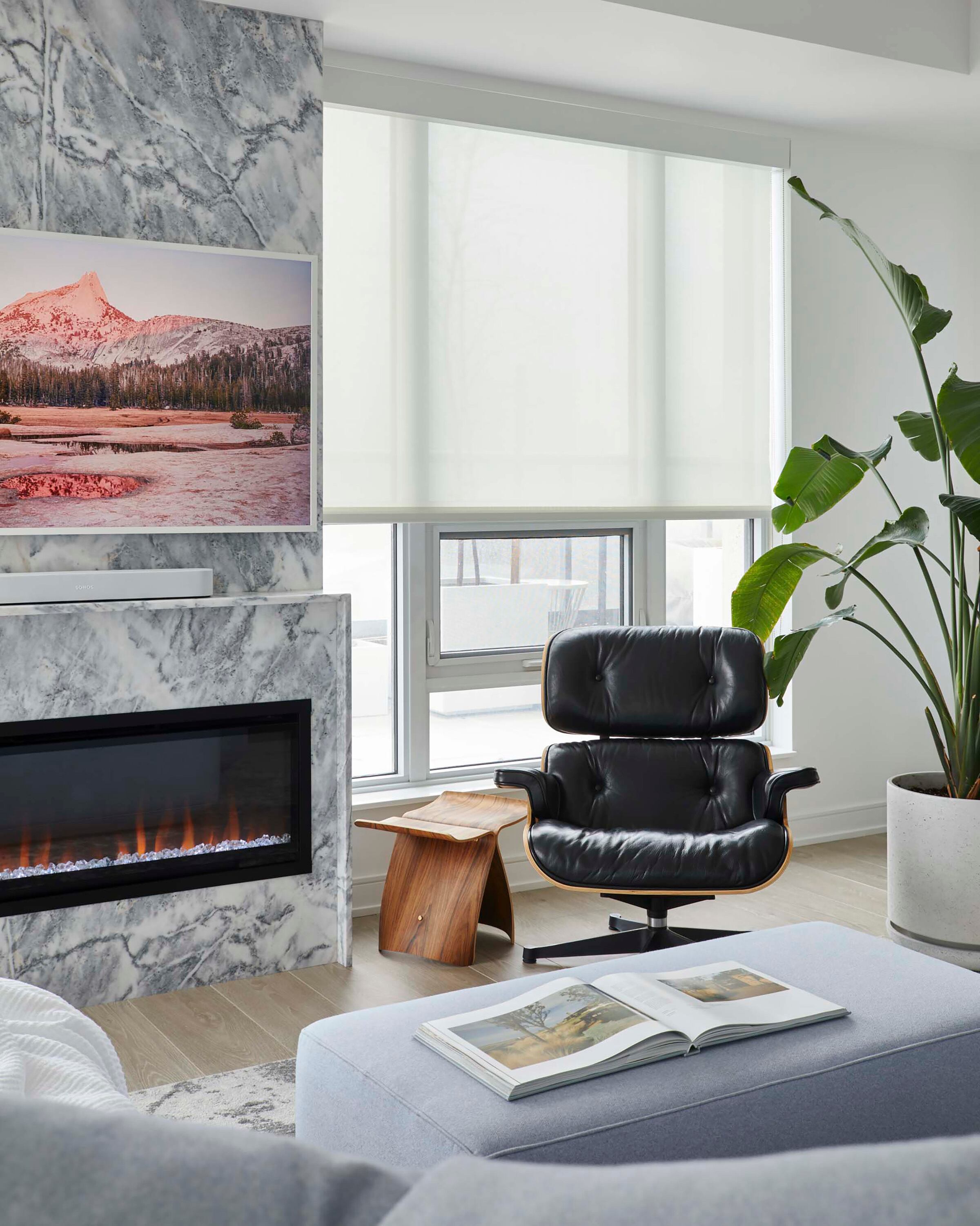 Sillón 'Lounge Chair & Ottoman' (Eames) en combinación con una pequeña mesa de arrime de madera.