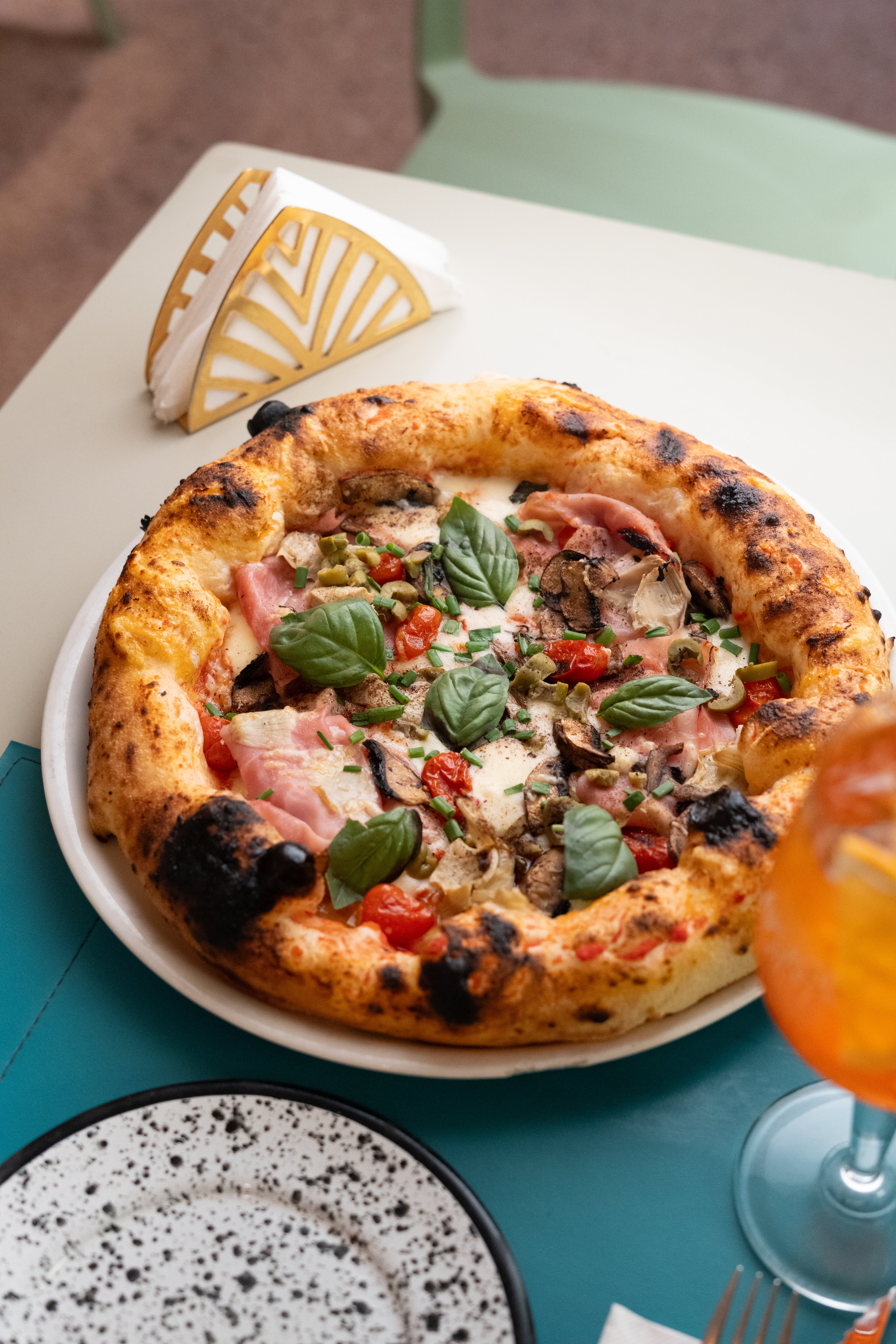 Pizza de panceta y funghi: mozzarella, provolone estacionado, panceta ahumada, portobello, ciboulette, sal de hongos negros y aceite de trufa blanca italiano