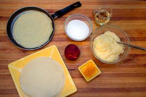 Panqueques rellenos con crema pastelera y duraznos flambeados