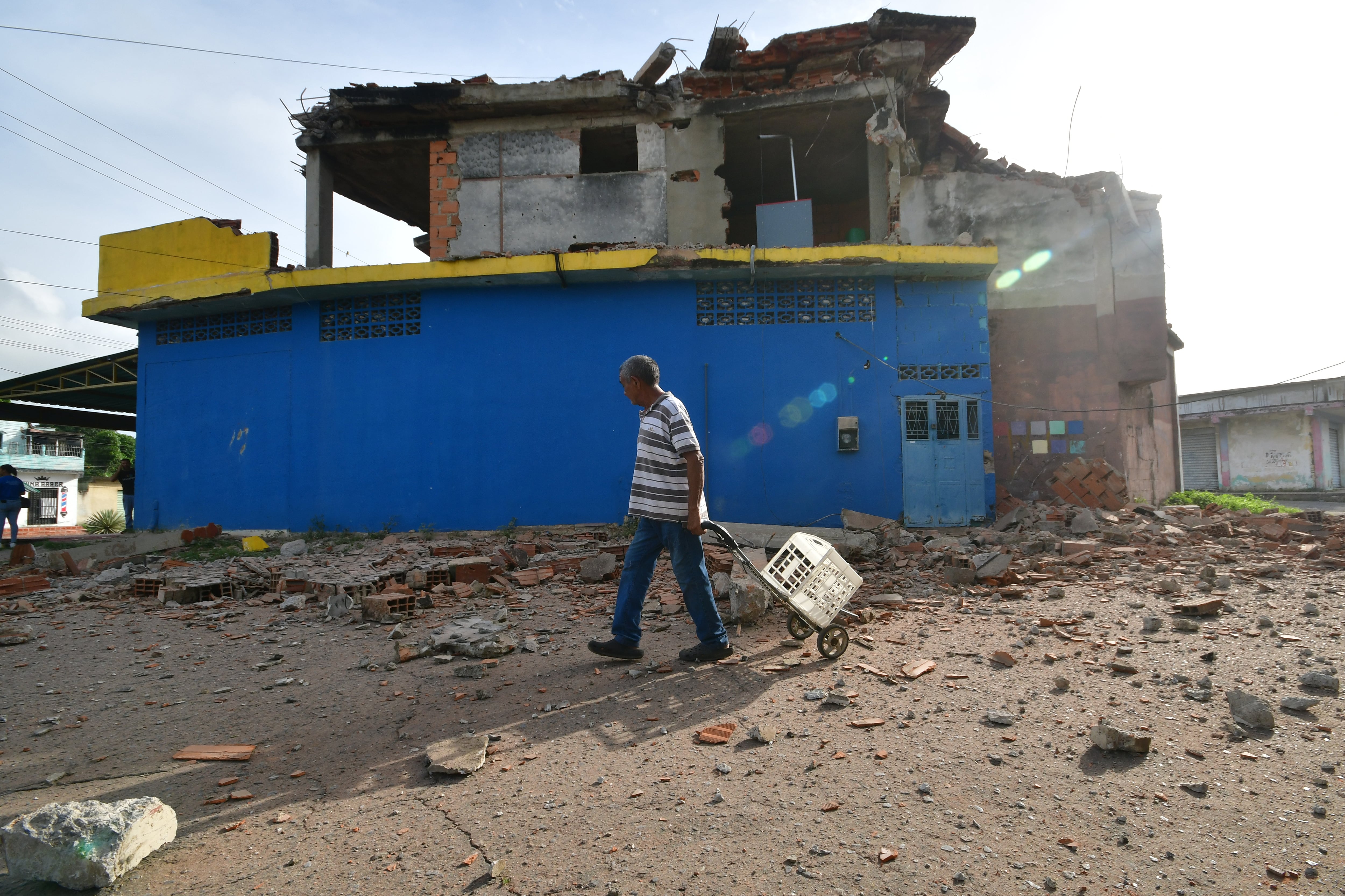 Un hombre camina frente a una vivienda dañada en Morón, cerca del epicentro de dos sismos