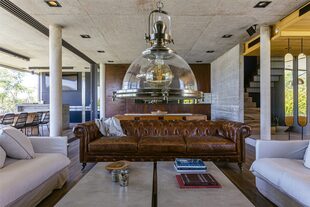 Sillón 'Chesterfield' (Landmark). Mesas ratonas hechas a medida con estructura de hierro cromado y piezas de porcelanato (Estudio Gambotto).