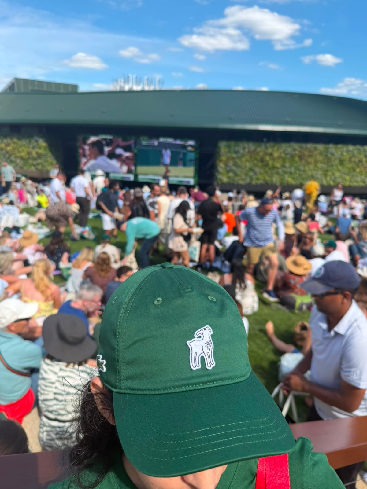 Silvina Funes, presidenta del club de fans oficial del serbio, luce orgullosa la cabra con la vista de los fans en un lugar emblemático de Wimbledon,