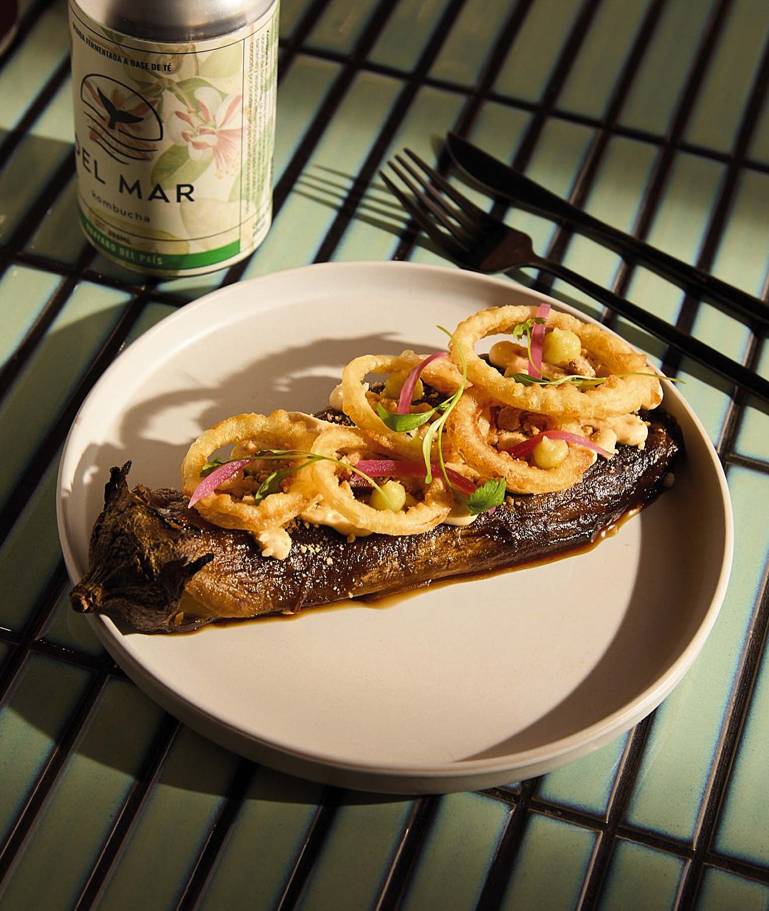 Berenjena ahumada, crema de maní, aros de cebolla y puré de cáscaras de limón