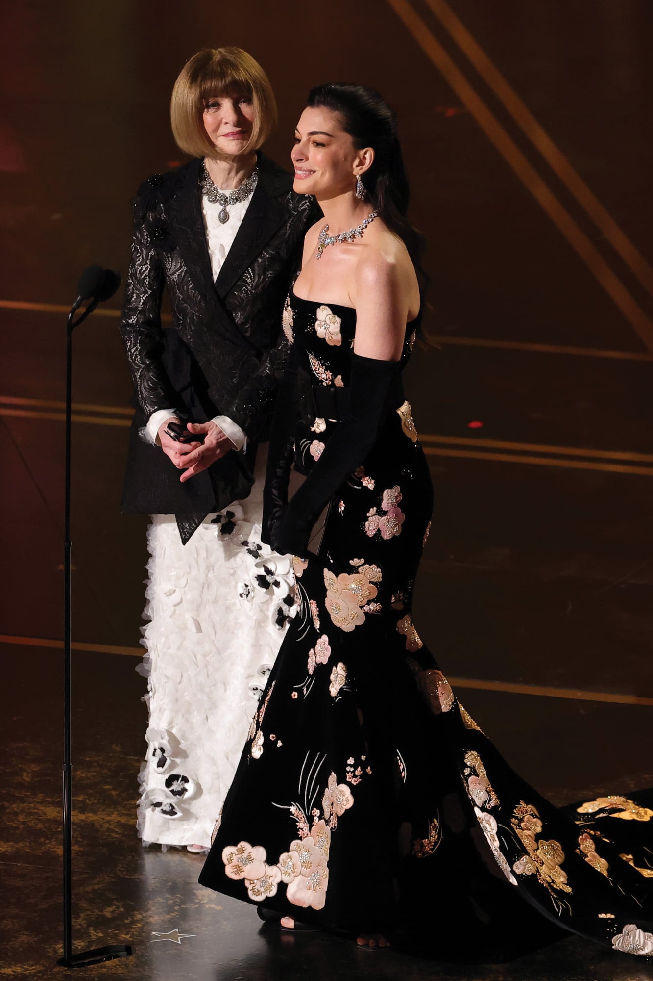 La editora de moda Anna Wintour, vestida por Dior, y Anne Hathaway, con un traje floral de Valentino y joyas de Bvlgari, protagonizaron un divertido skecth, recordando que Anne intrepretó a la asistente de la estricta directora de una revista en