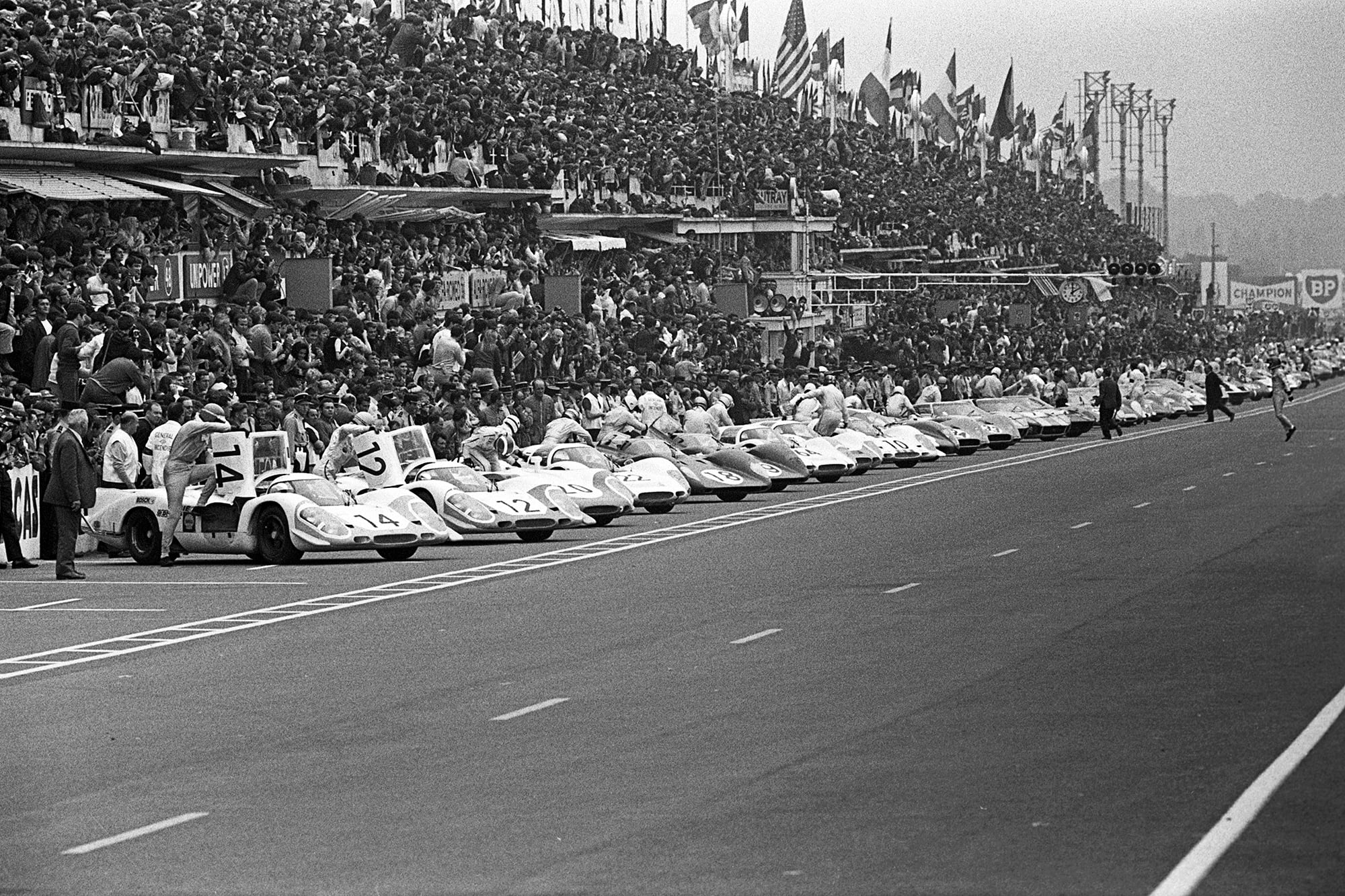 Todos los pilotos ya están en sus autos, menos uno: Jacky Ickx, que se dirige tranquilamente hacia el suyo (a la derecha, en el medio de la pista)