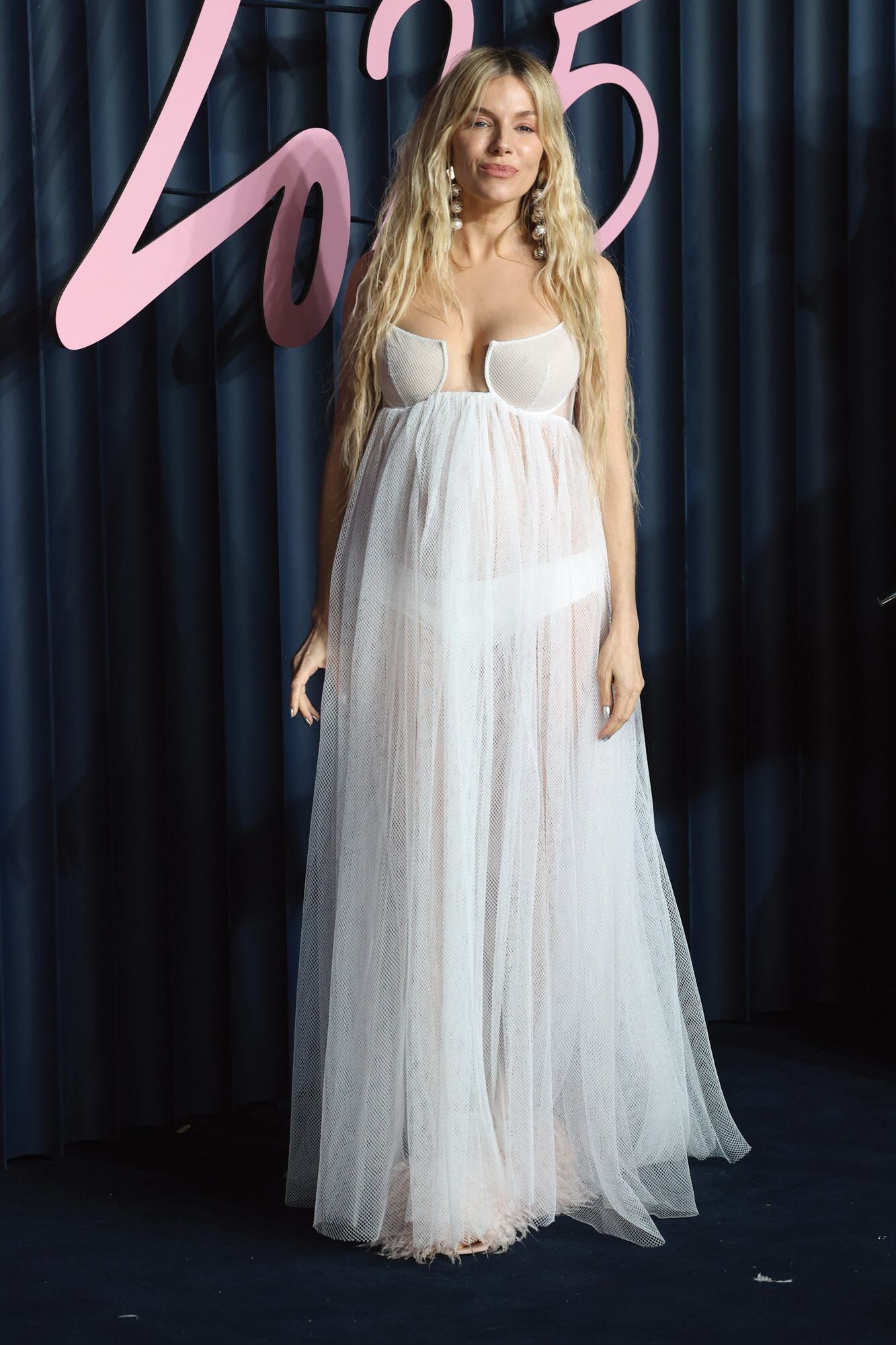 Sienna Miller, embarazada por tercera vez (espera junto a su marido, Oli Green, el segundo hijo en común), con un strapless transparente de Givenchy