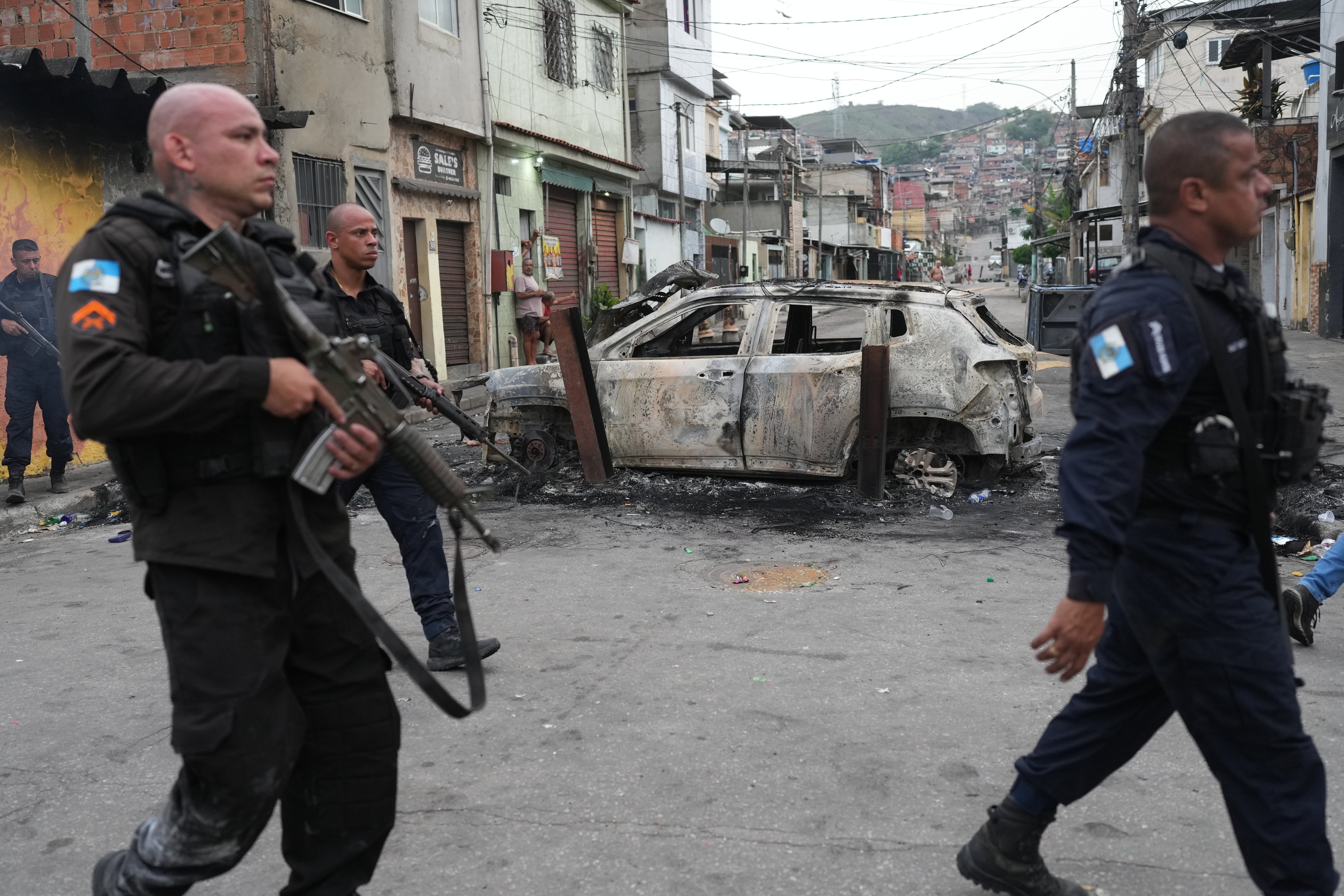 Autos incendiados forman una barricada en la favela Penha