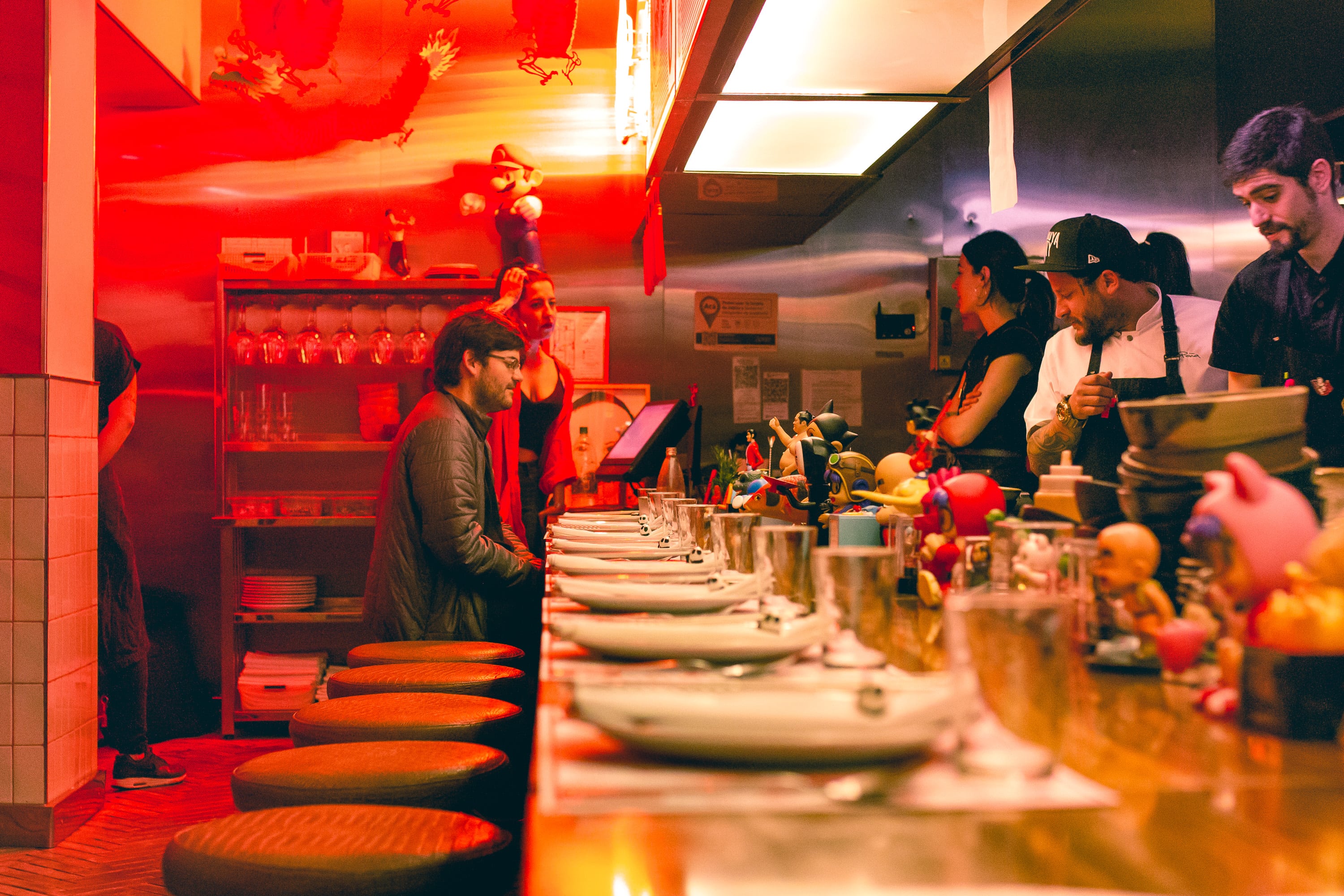 La barra tiene apenas once lugares, un número impar ideal para conversar con los cocineros, los vecinos y observar el frenético servicio