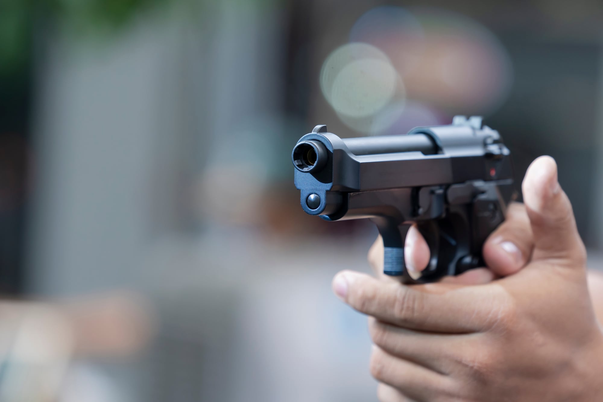 Man holding gun aiming pistol in hand ready to shoot. The criminal robber or gangster thief concept