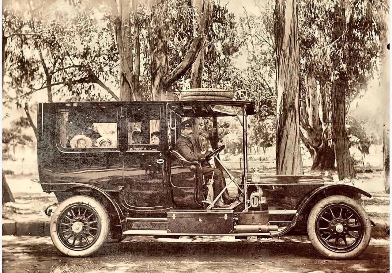 El Rolls-Royce Silver Ghost estacionado junto a un parque con algunos de los sobrinos de los sobrinos de Laura Preyra Iraola en el interior del vehículo y el chofer contratado para la travesía. (Cortesía familia Pereyra Iraola)