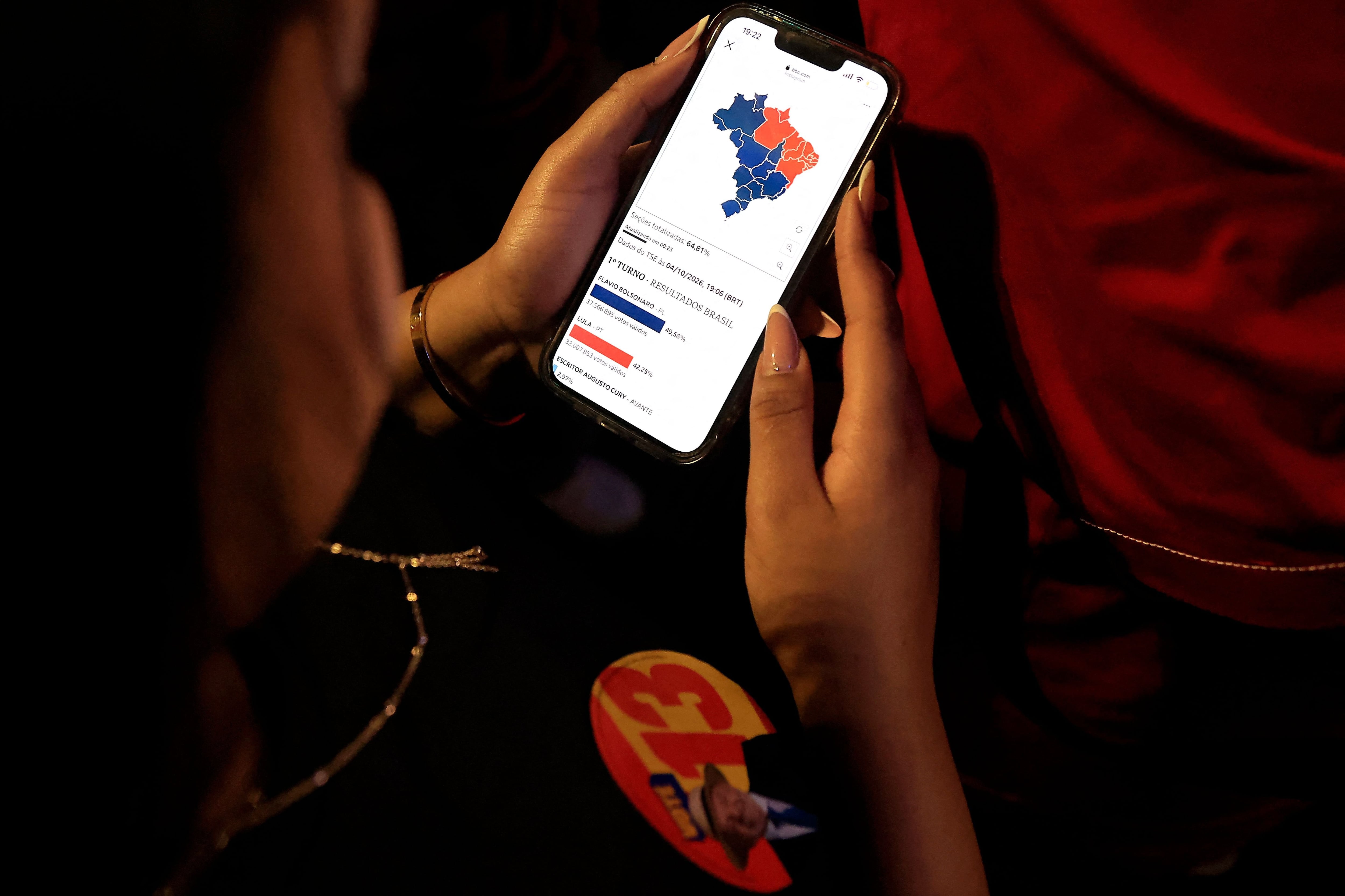 Un partidario del presidente y candidato presidencial de Brasil, Luiz Inácio Lula da Silva, consulta los resultados parciales de las elecciones presidenciales en un teléfono móvil en Río de Janeiro, Brasil, el 4 de octubre de 2026