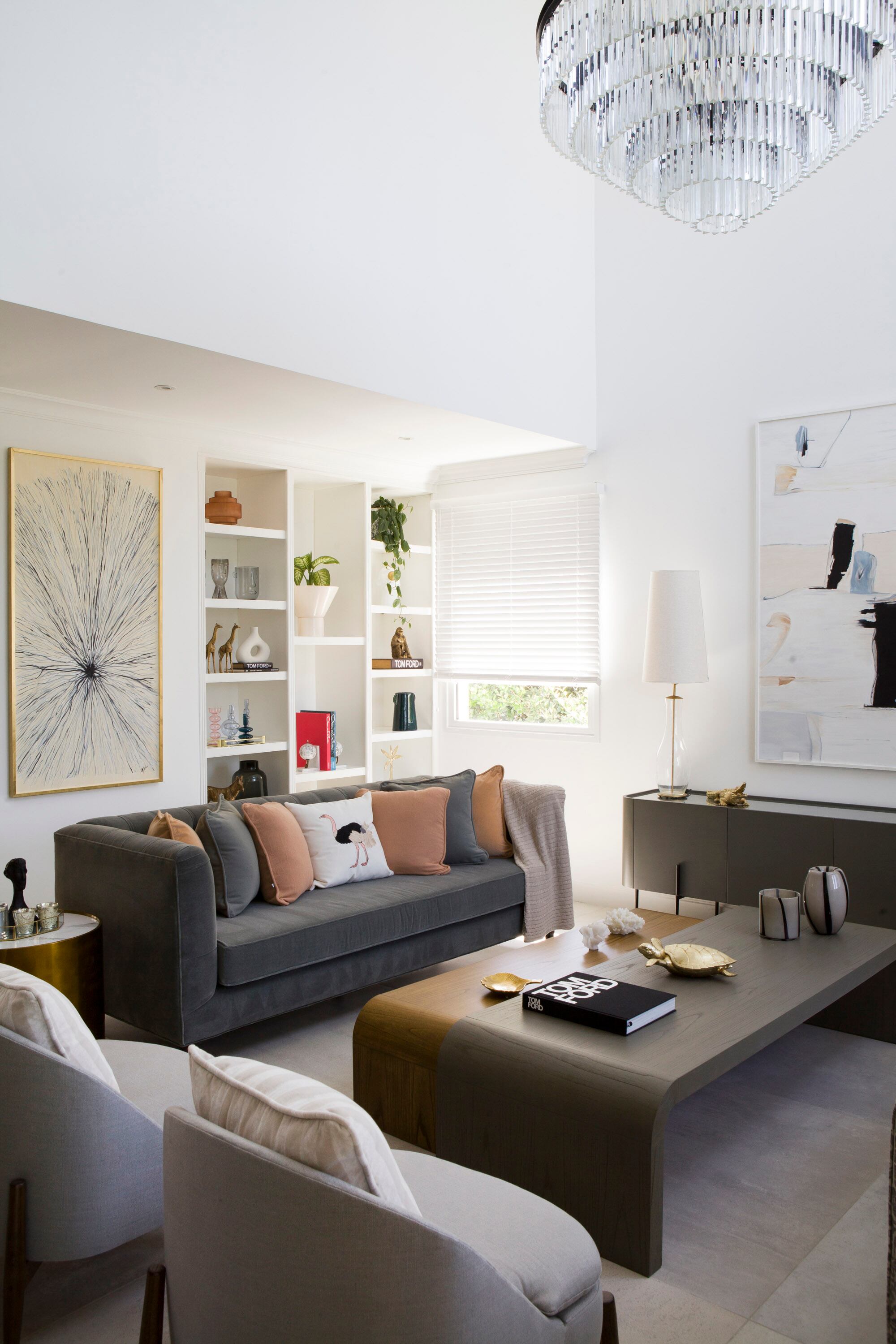 Mesas bajas solapables, butacas individuales y lámpara de caireles (todo de Agustina Cerato).