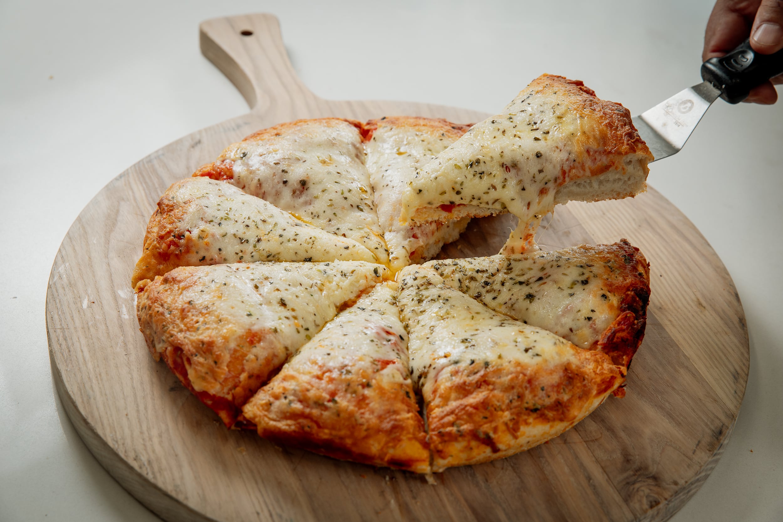 La pizza al Molde Porteña está inspirada en las pizzerías históricas de la avenida Corrientes, con masa media-alta, abundante muzzarella y formato de ocho porciones y 800 gramos