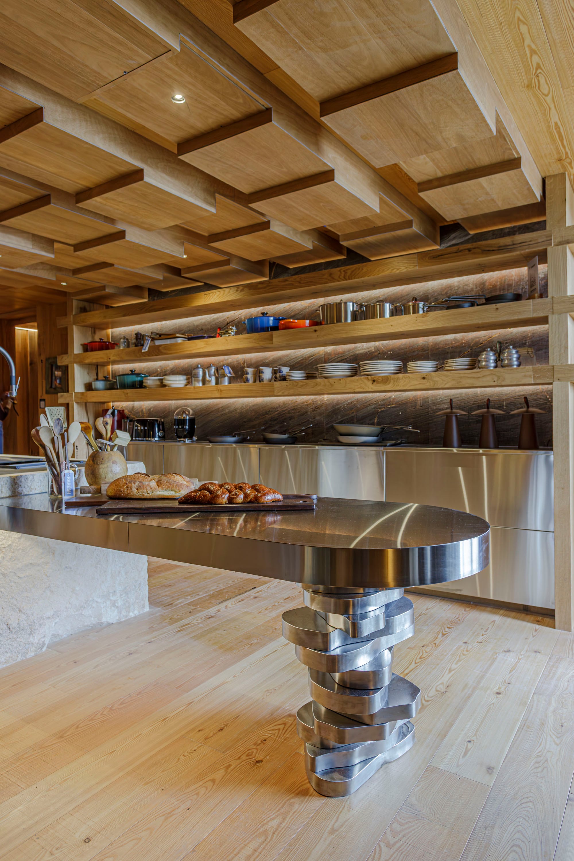 En un ángulo de la cocina proyectada para Mallmann, isla en acero inoxidable con pata móvil (Artefacto) creada con módulos cortados con láser bajo un impactante cielo raso de roble