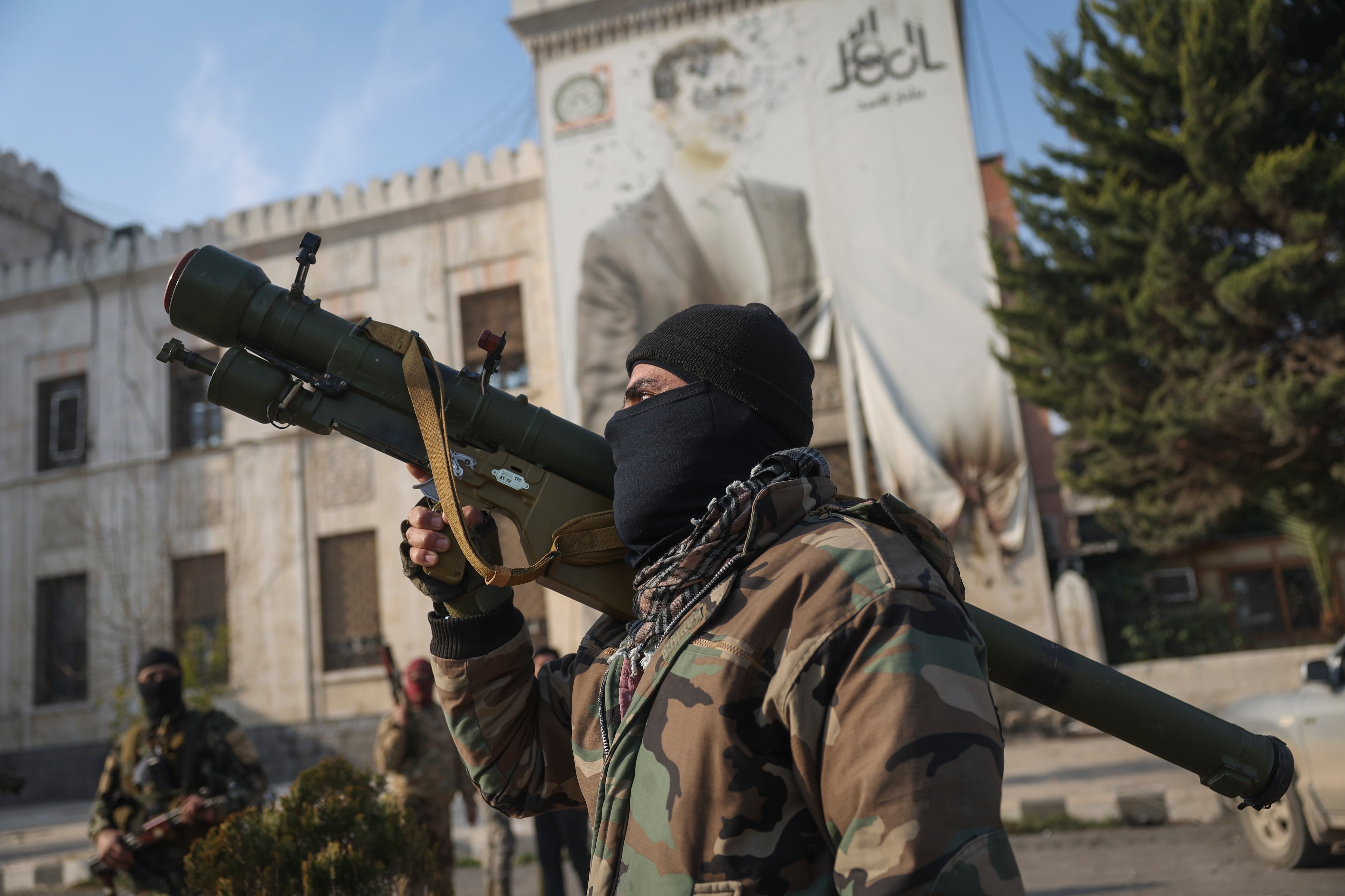 Un combatiente rebelde sostiene un lanzacohetes frente a la oficina del gobierno regional en Hama