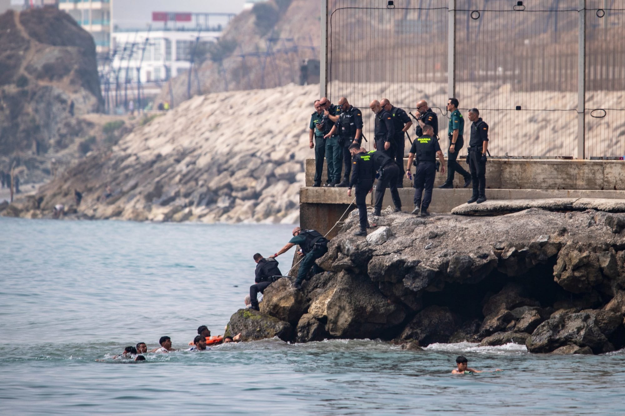 Migrants try to cross into the Spanish enclave of Ceuta from Morocco, Thursday, July 30, 2026. (AP Photo/Antonio Sempera)
