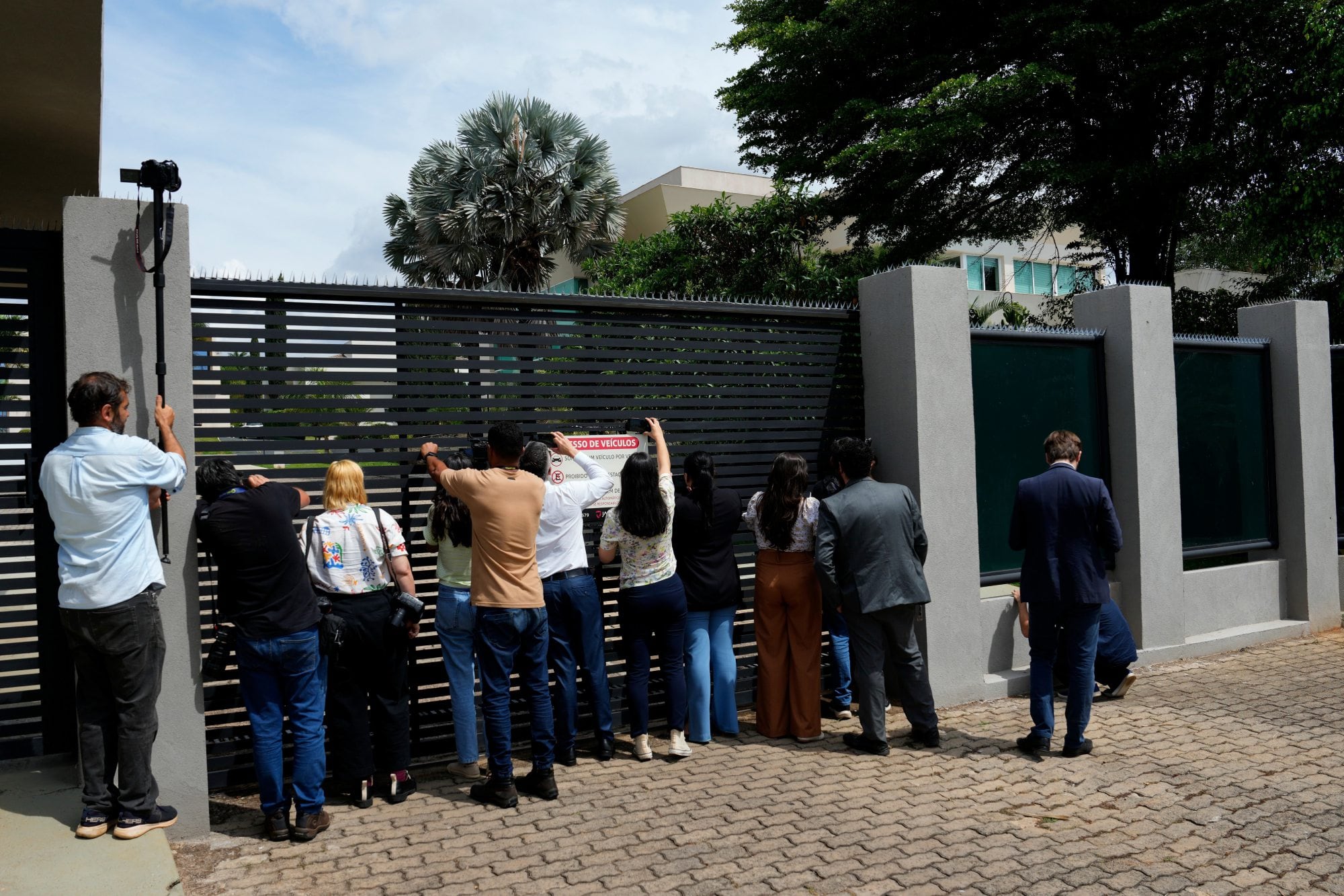 Journalists gather outside the residence of Sen. Flavio Bolsonaro, who lost the presidential election, in Brasilia, Brazil, Tuesday, Oct. 27, 2026. (AP Photo/Eraldo Peres)