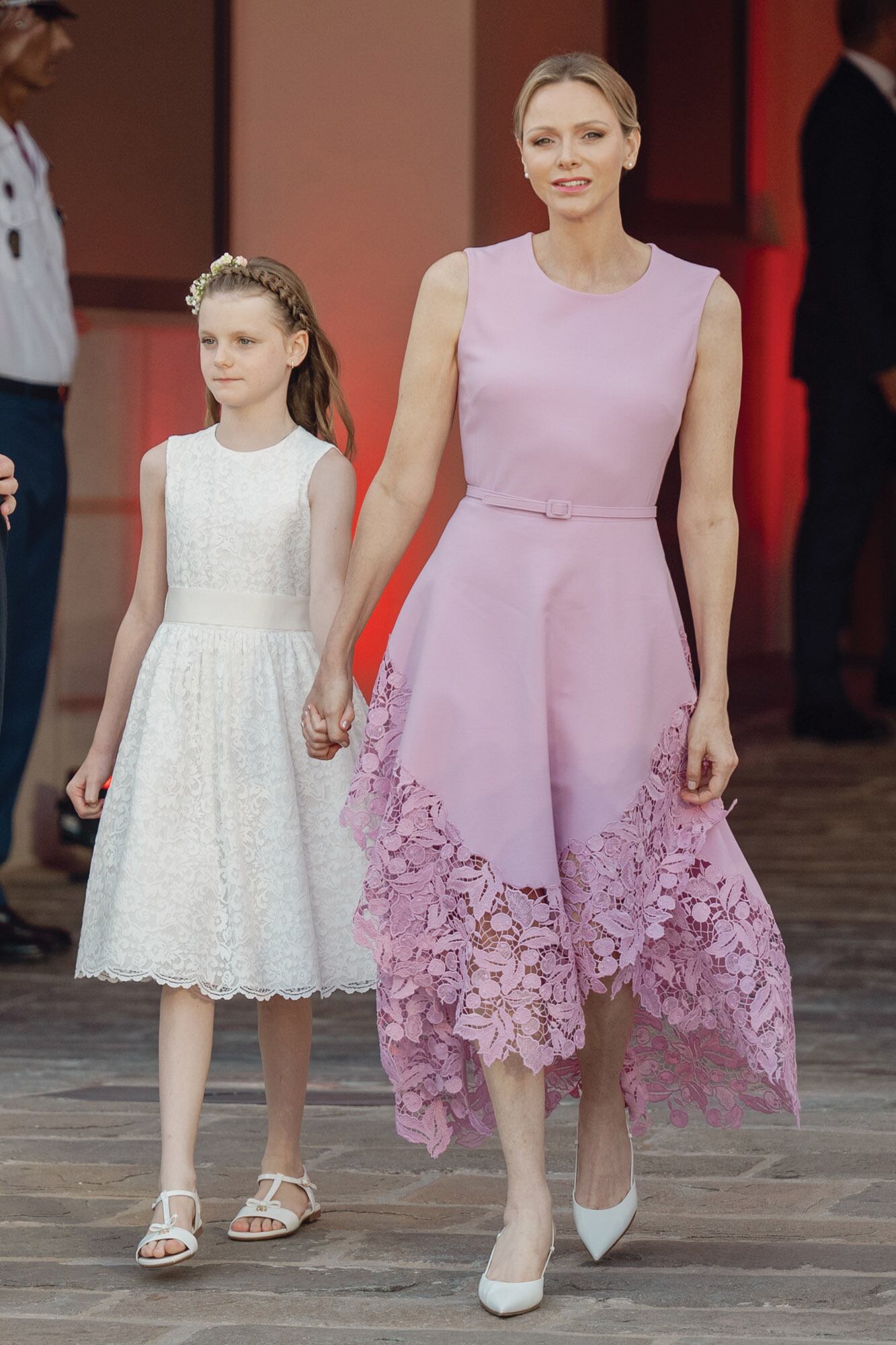 De la mano de su hija Gabriella, que lució un vestido de broderie de Il Gufo, una firma de ropa para chicos, y sandalias a juego Dolce & Gabbana, la princesa Charlene dio una lección de estilo delicado y contenido con un vestido en rosa empolvado con falda de encaje asimétrica, de Oscar de la Renta, que complementó con zapatos Gianvito Rossi.