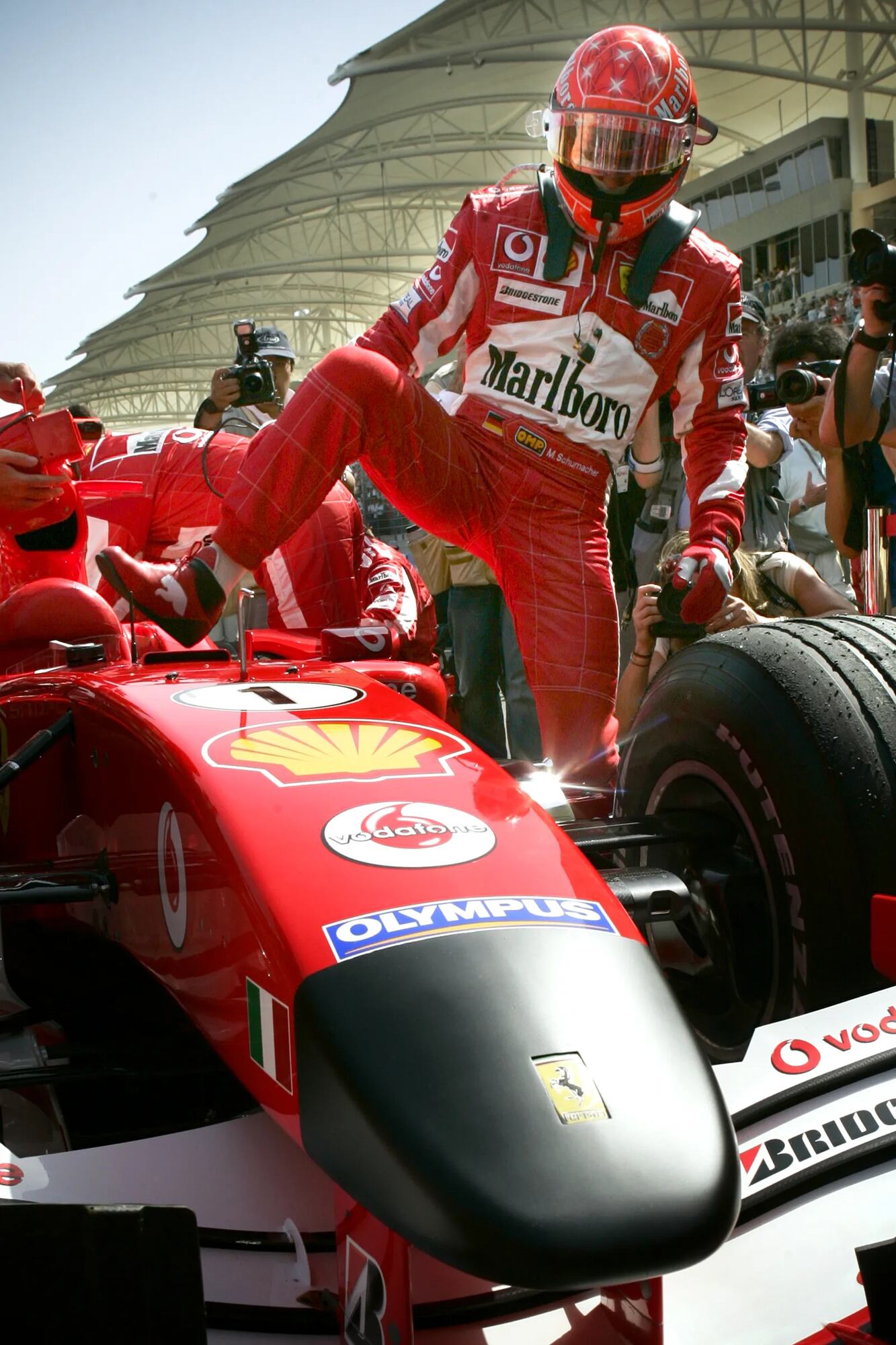 Michael Schumacher entra a su Ferrari para largar en el Gran Premio de Bahréin, el 3 de abril de 2005; es el día siguiente al del fallecimiento de Juan Pablo II y el equipo italiano homenajea al papa polaco con una suerte de crespón negro en la punta de sus autos.