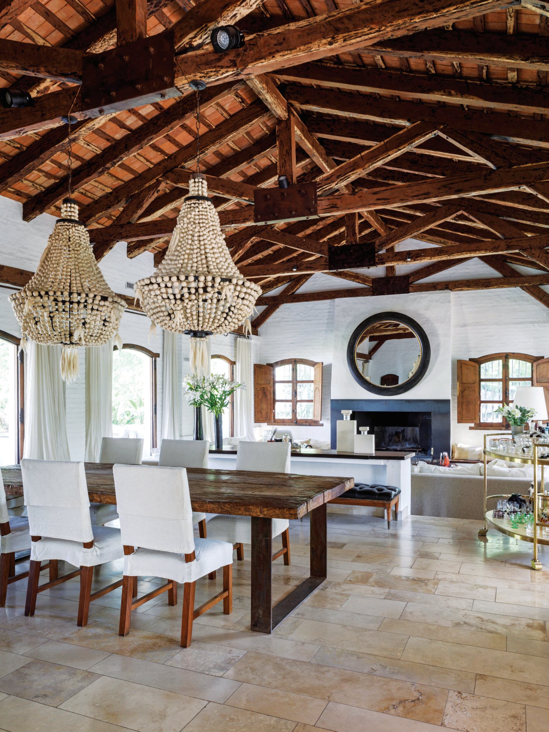 “Preservamos lo que definía identidad, como el techo de 8m de altura con vigas de quebracho traídas del norte”, nos dijo cuando la visitamos en su casa, que compraron prácticamente en estado de demolición y recicló por entero. Sobre el hogar, que se usa hasta para hacer asados, espejo de 1,80m de diámetro.