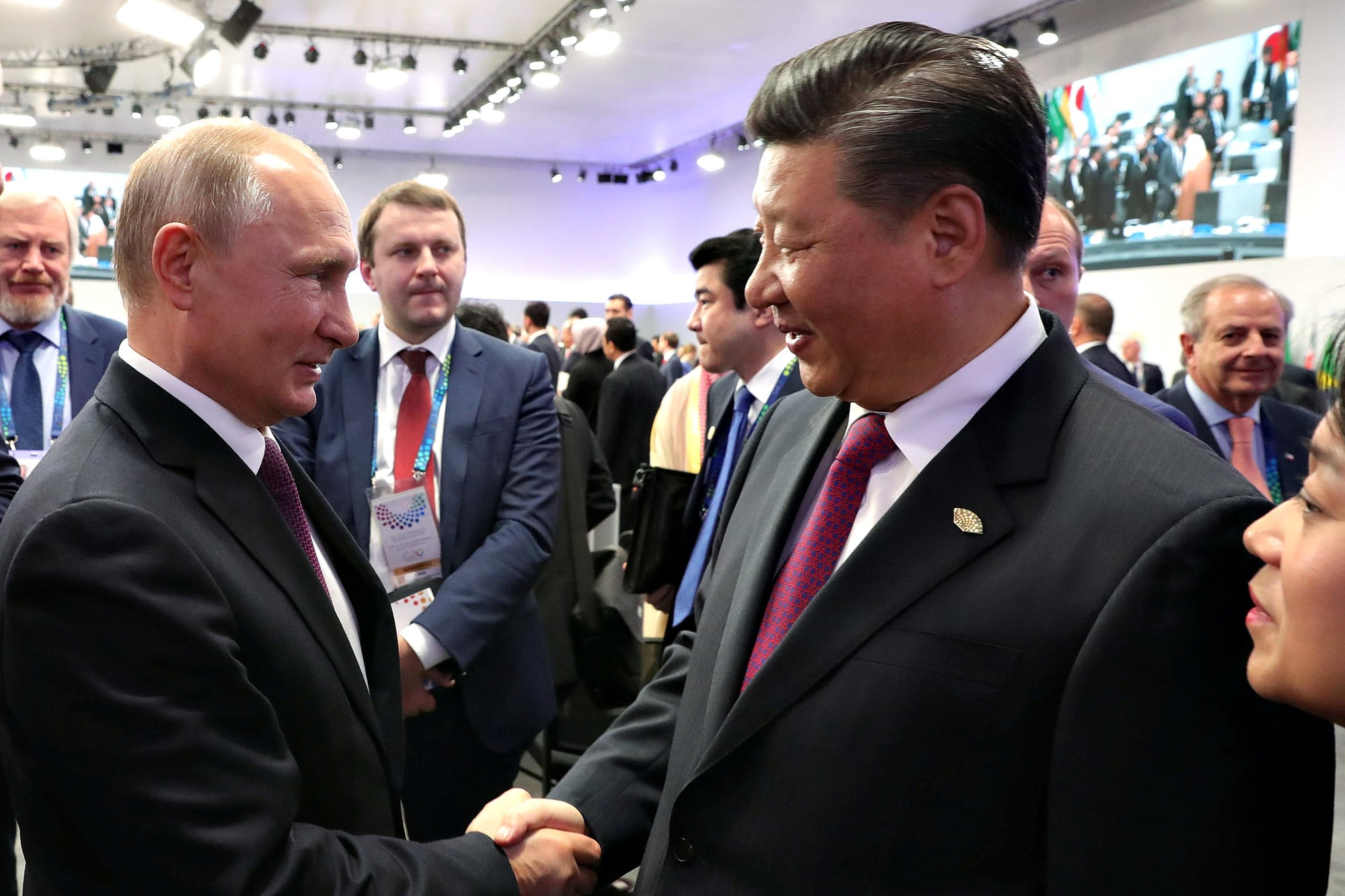 El presidente ruso Vladimir Putin saluda a Xi Jinping, presidente de China