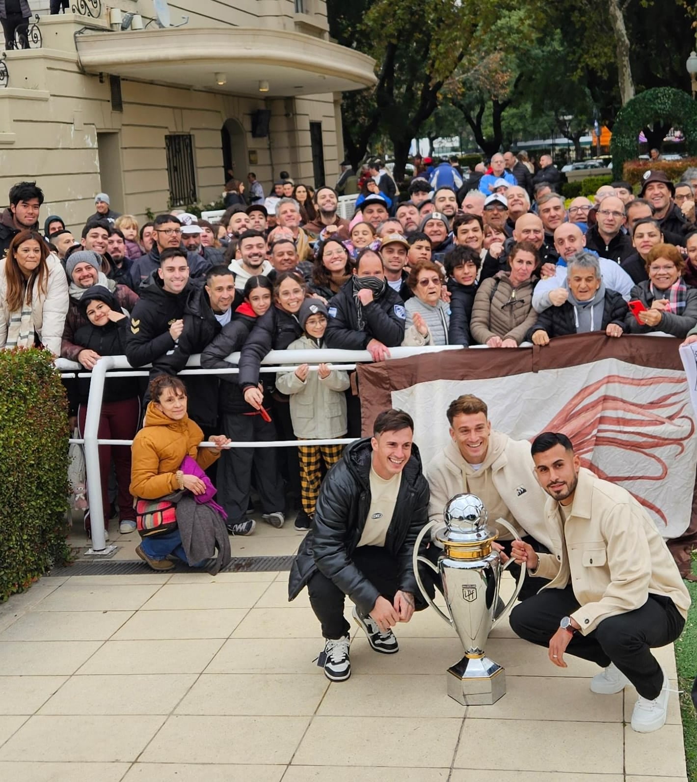 Augusto Lotti, Guido Mainero y Nacho Vázquez, los futbolistas campeones con Platense que estuvieron con el trofeo del Apertura 2025 en el hipódromo de Palermo, rodeado de aficionados