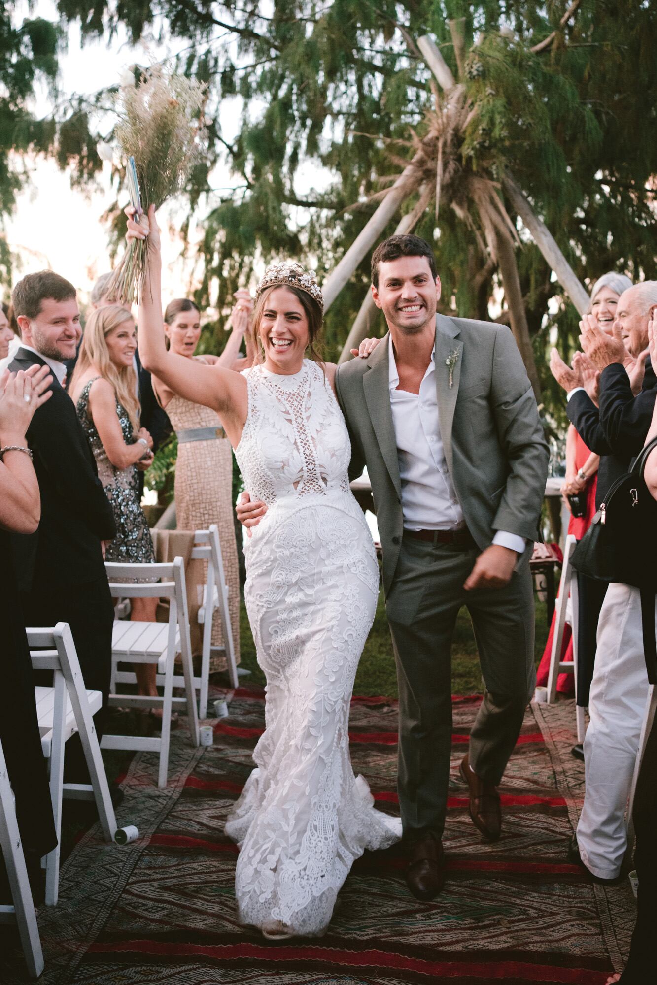 Mateo eligió un look relajado, sin corbata. Vicky, en tanto, llevó un traje con escote camiseta, silueta sirena y cola, que acompañó con corona decorada con flores frescas.