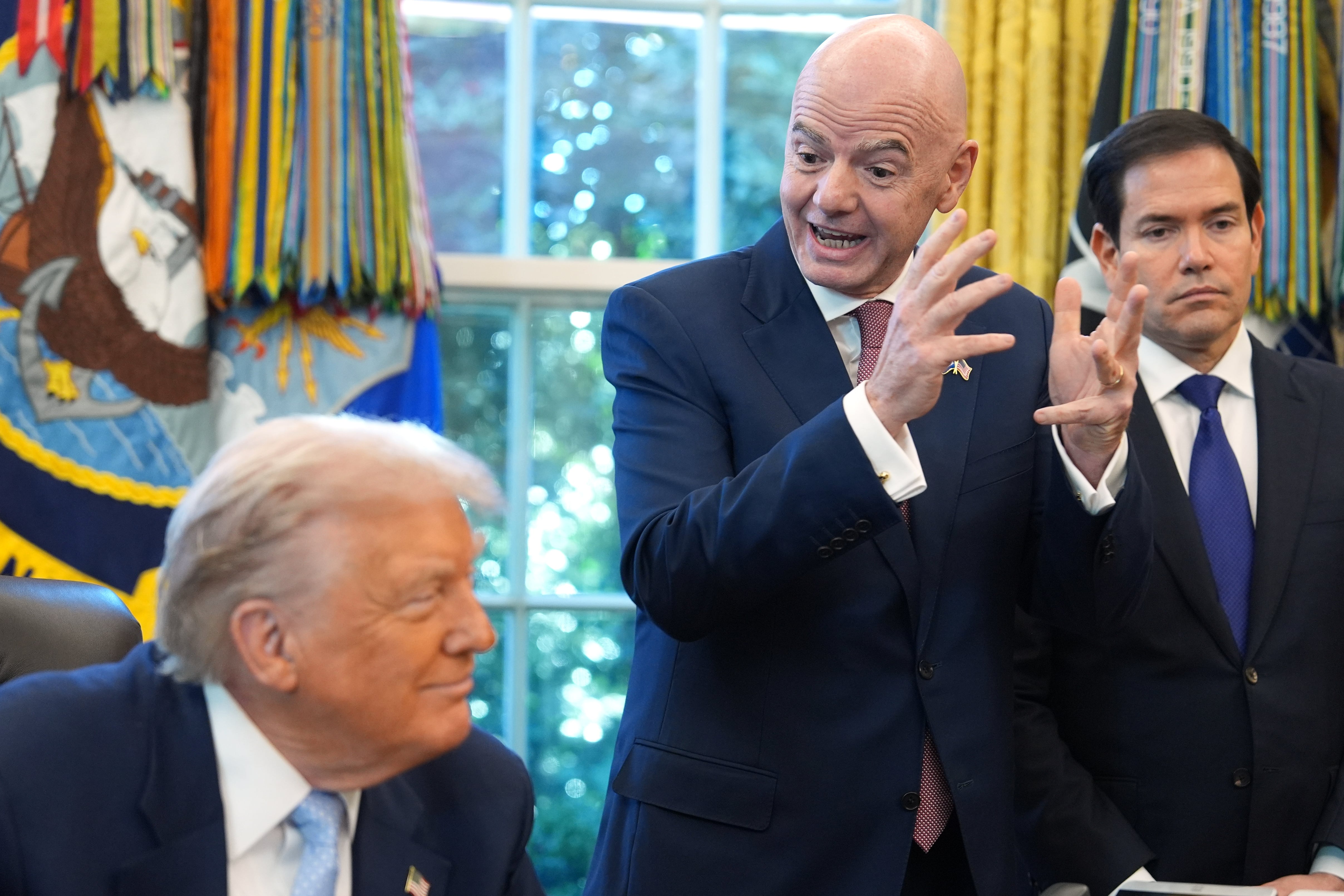President Donald Trump and Secretary of State Marco Rubio listen as FIFA President Gianni Infantino speaks during a meeting with White House staff on the 2026 FIFA World Cup.