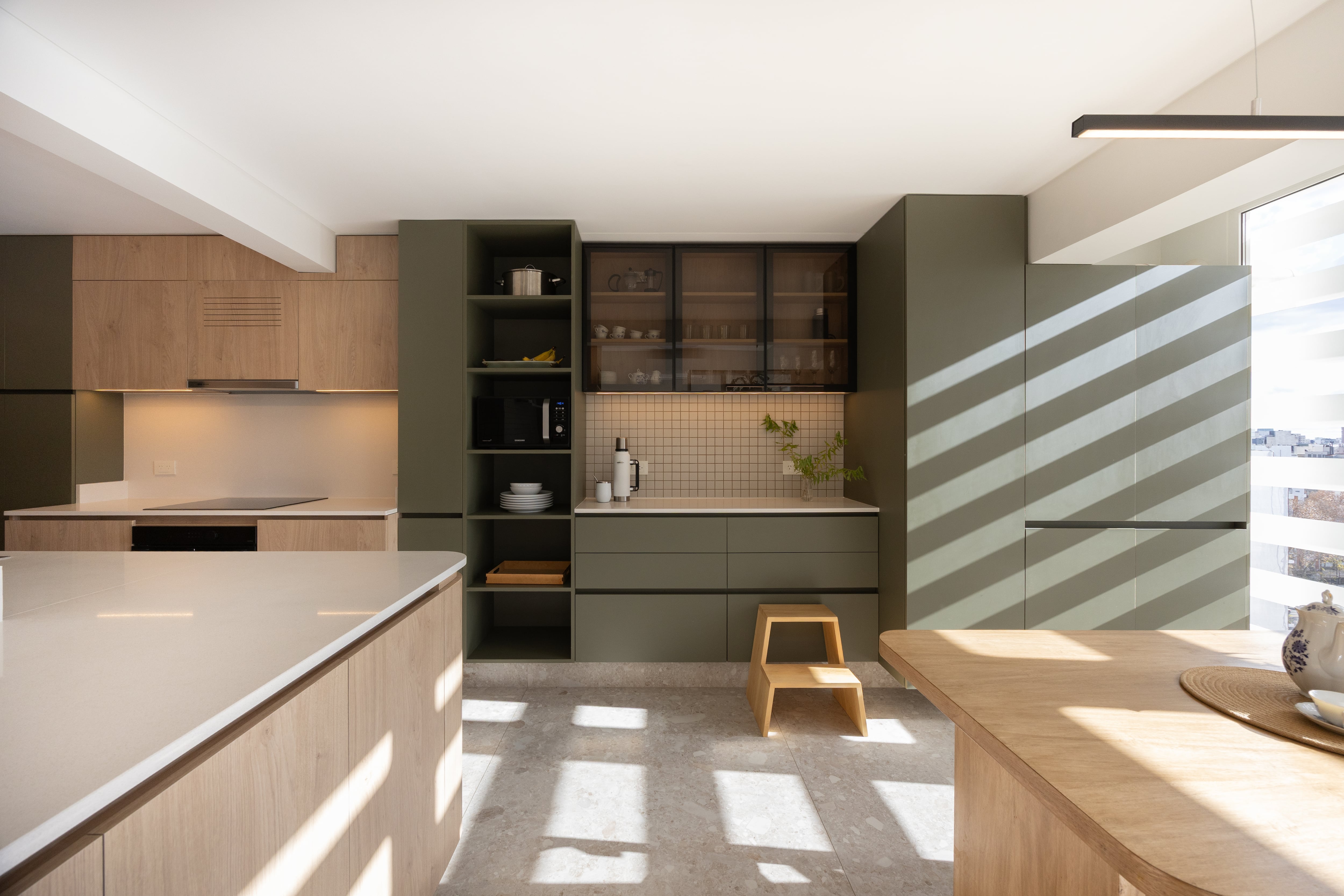 La melamina en verde y madera se alternan en una paleta cálida y contemporánea.