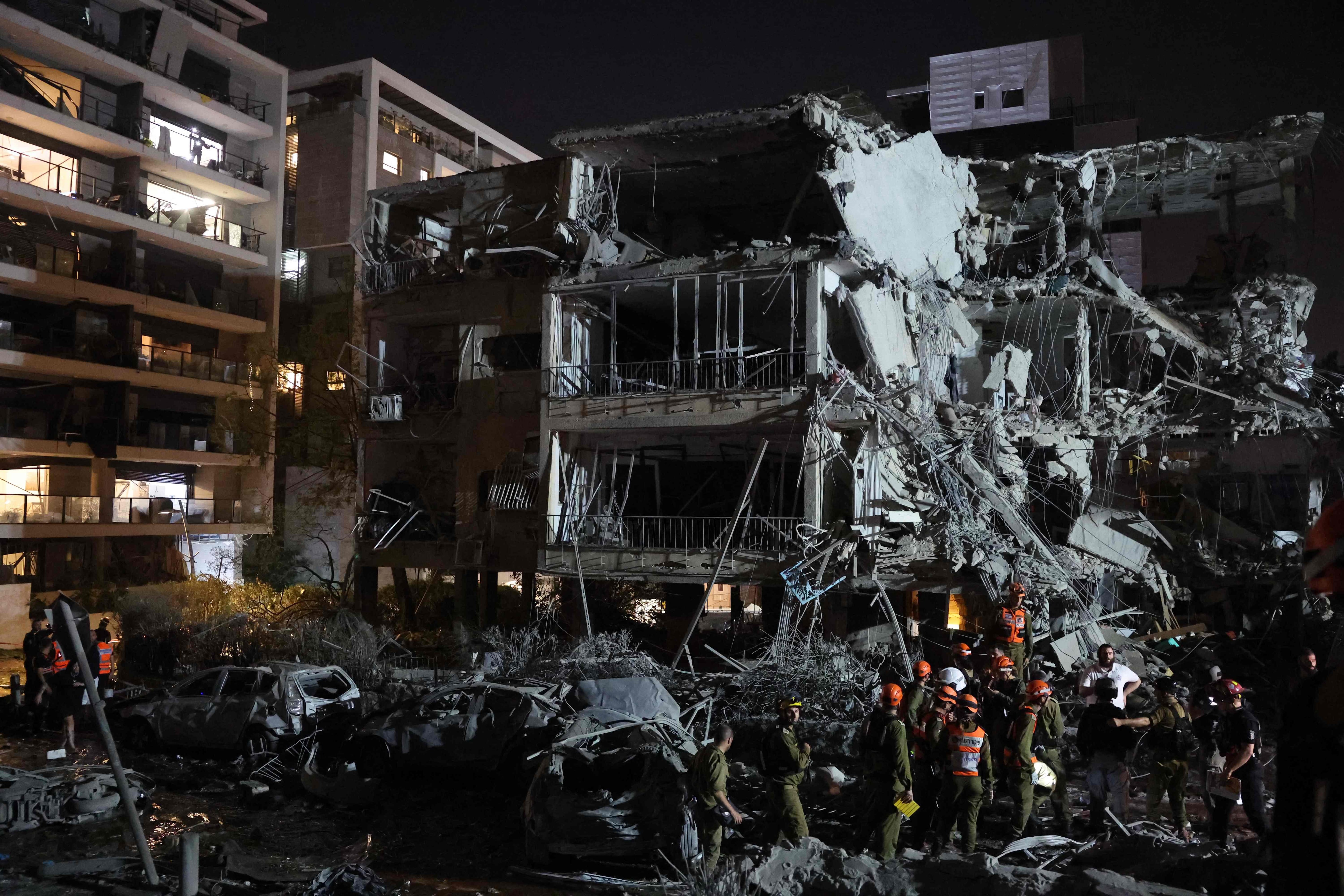 Tropas israelíes y personal de emergencia se reúnen frente a un edificio alcanzado por un misil lanzado desde Irán, en Tel Aviv, el 13 de junio de 2025