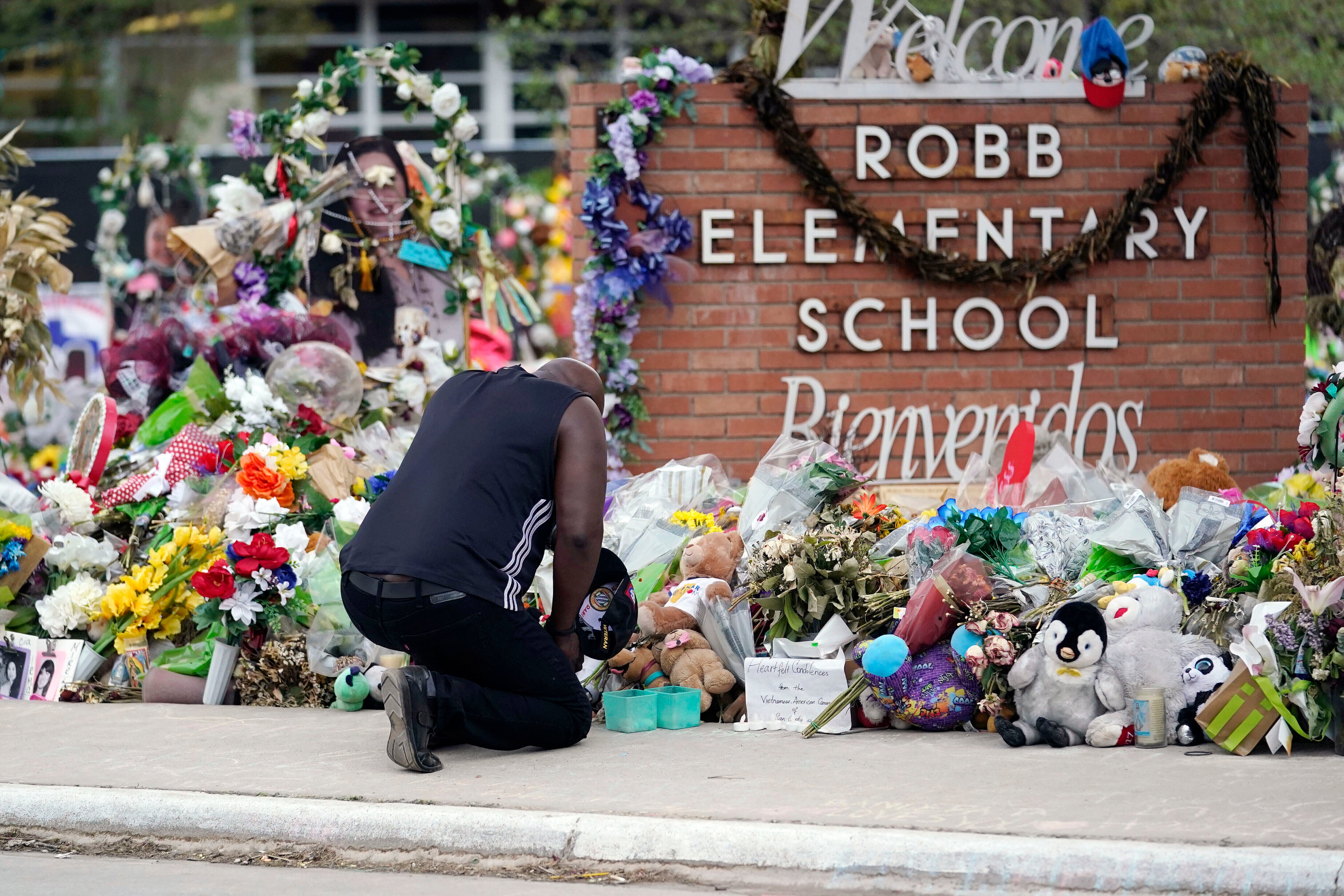 ARCHIVO - Reggie Daniels rinde homenaje a las víctimas de un tiroteo escolar en un altar colocado en la Escuela Primaria Robb, el jueves 9 de junio de 2022, en Uvalde Texas. (AP Foto/Eric Gay, Archivo)