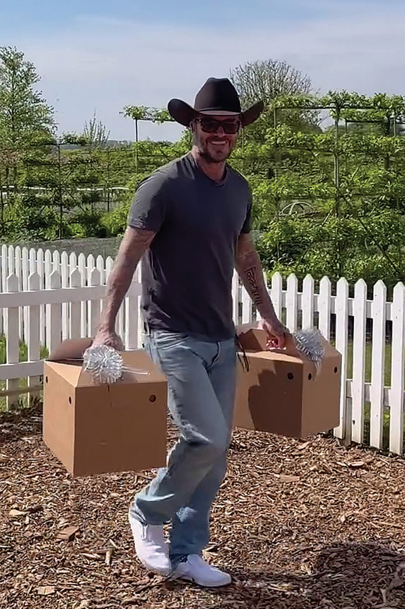 Beckham carga
las cajas con
moños blancos
mientras entra al
gallinero que tiene
en su finca de los
Cotswolds