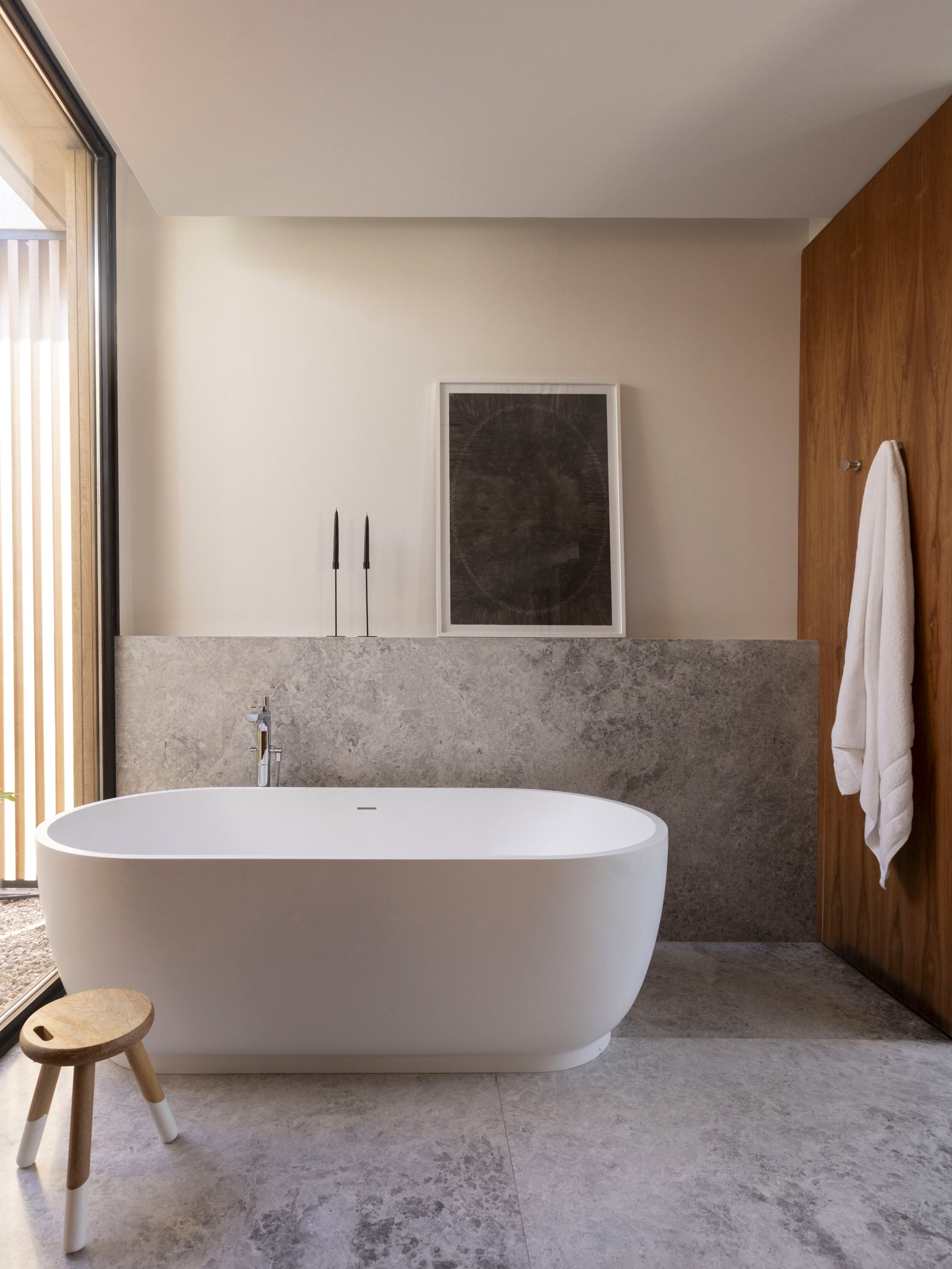 En el baño de la suite, un antepecho de mármol da apoyo a la obra de Andrés Latorre (Diderot.art) junto a la bañadera exenta en Solid Surface (De Stefano). Banquito ‘Oriente Milk’ (Krethaus).