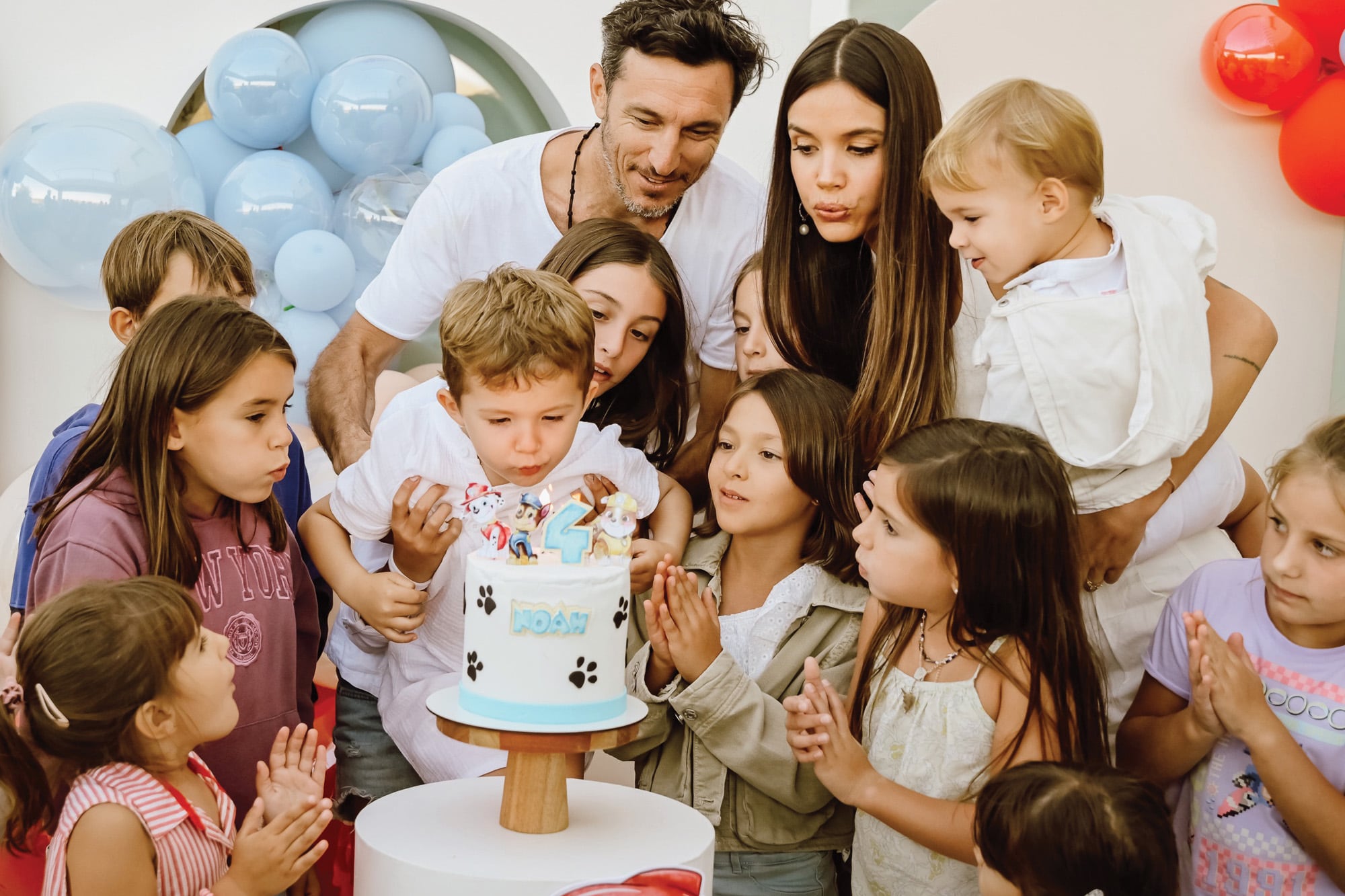 Mientras el cumpleañero sopla las velitas, su familia y sus invitados lo ayudan